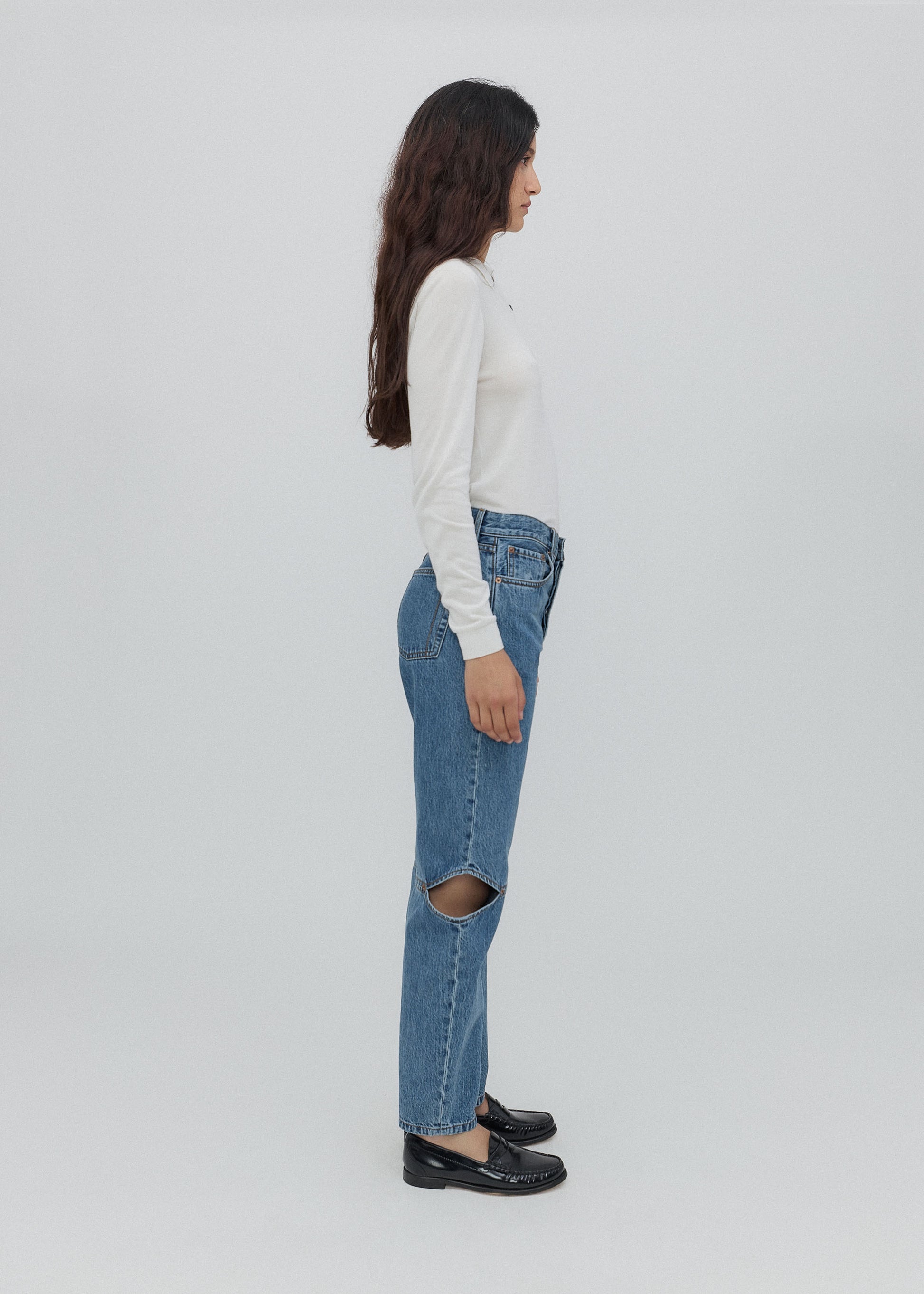 Person wearing blue jeans with a white background