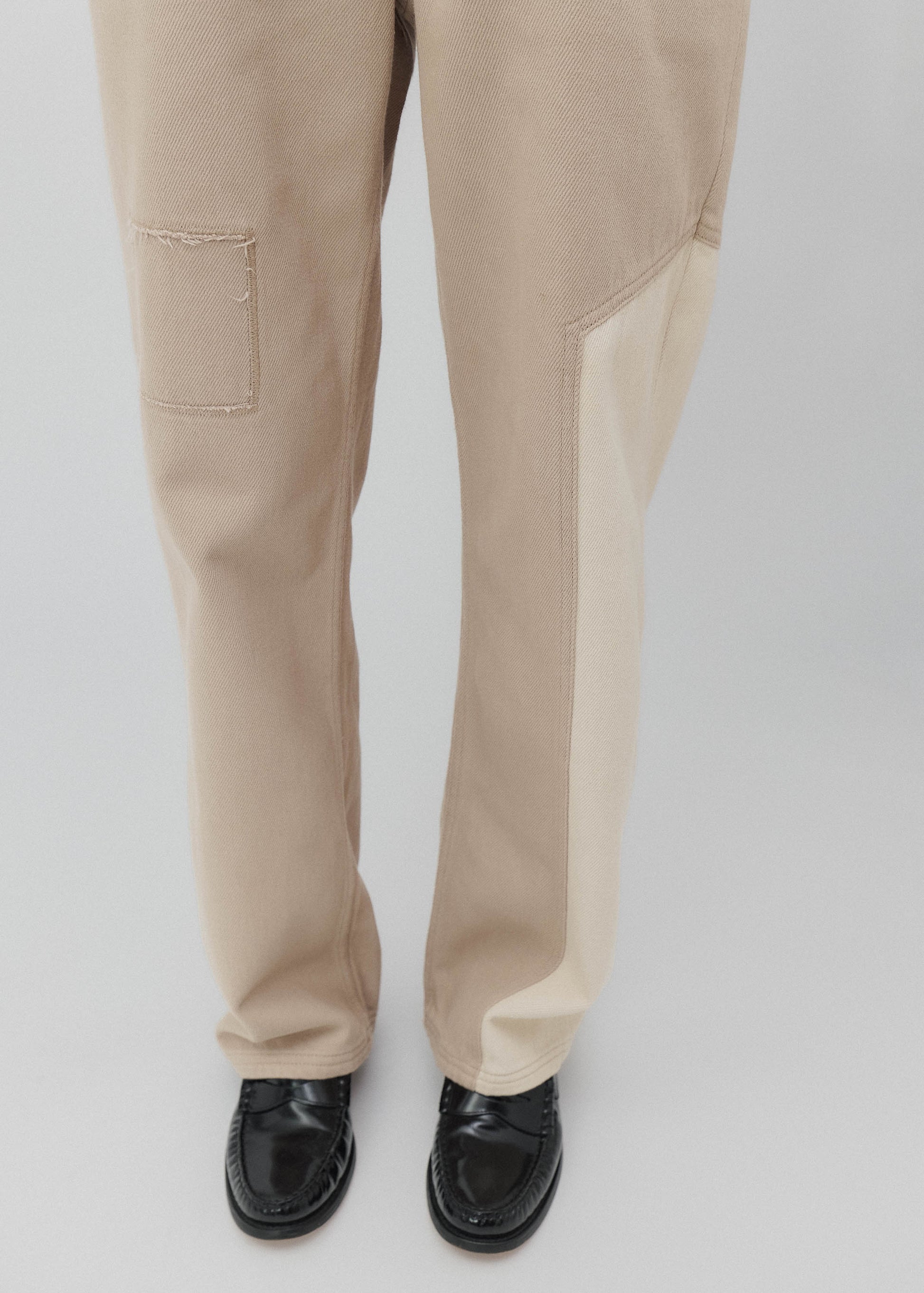Beige pants worn by a person on a light gray background