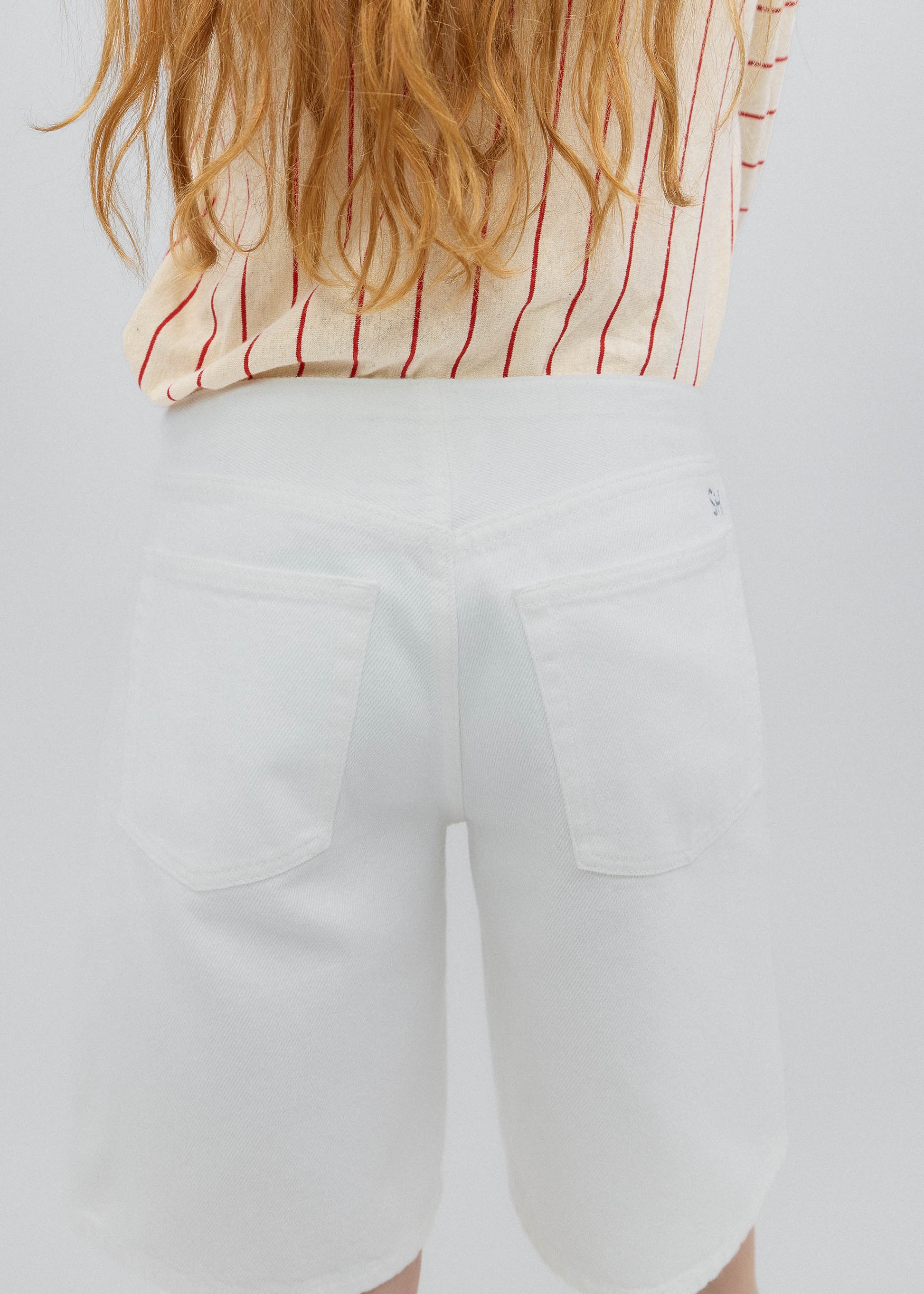 Person wearing a red and white striped shirt with a blurred background