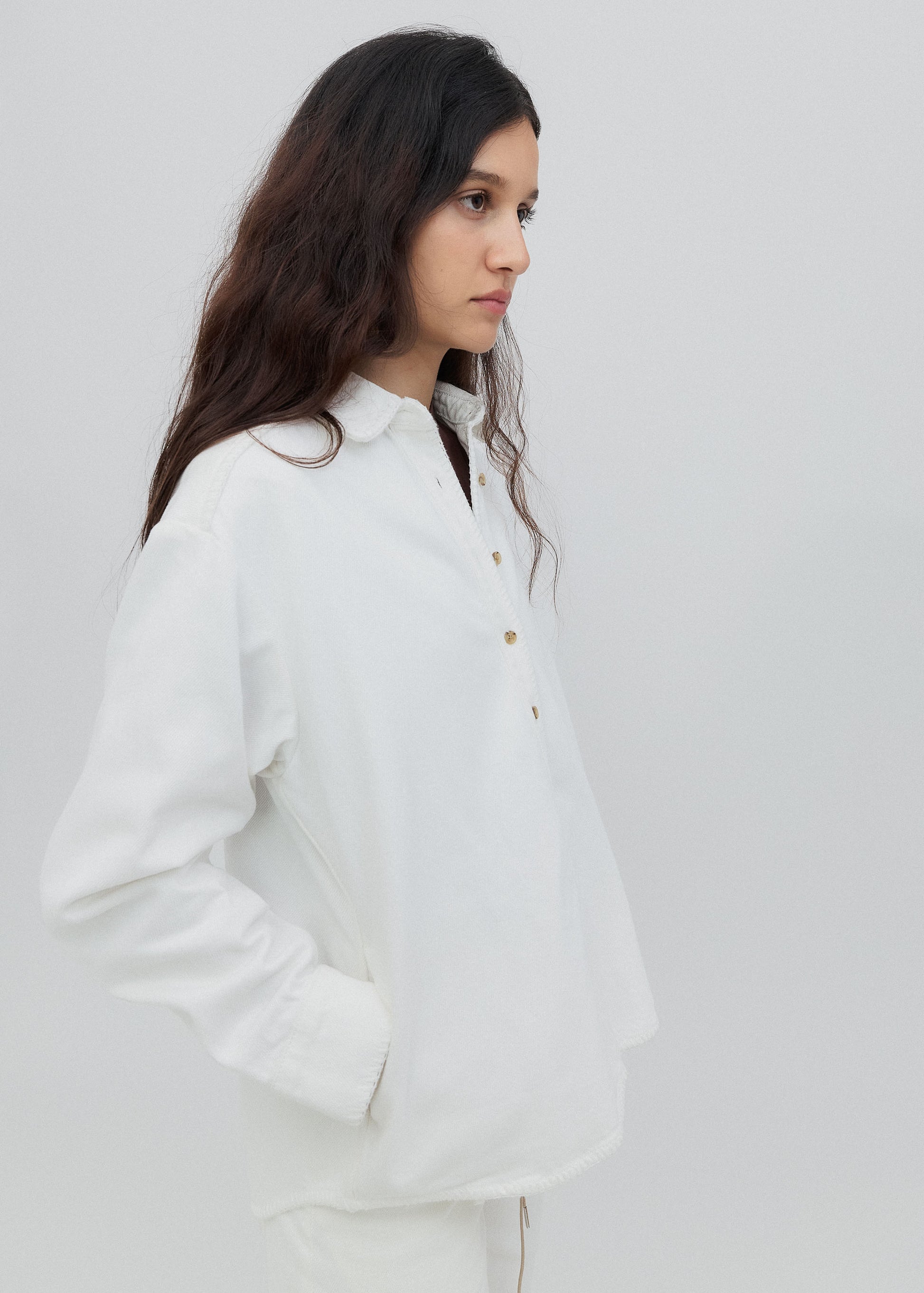 Woman wearing a white shirt against a plain background