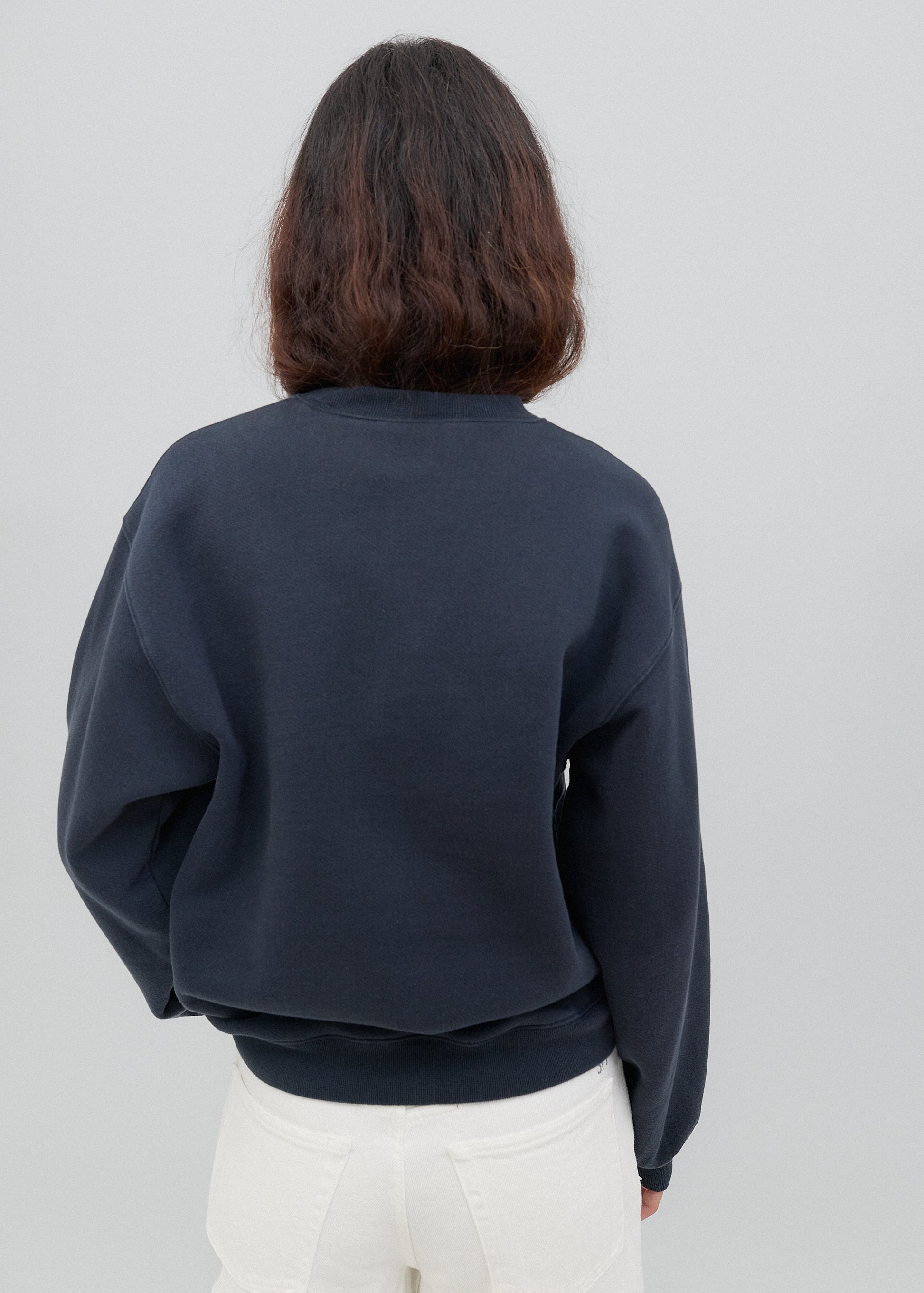 Person wearing a navy blue sweatshirt against a plain background