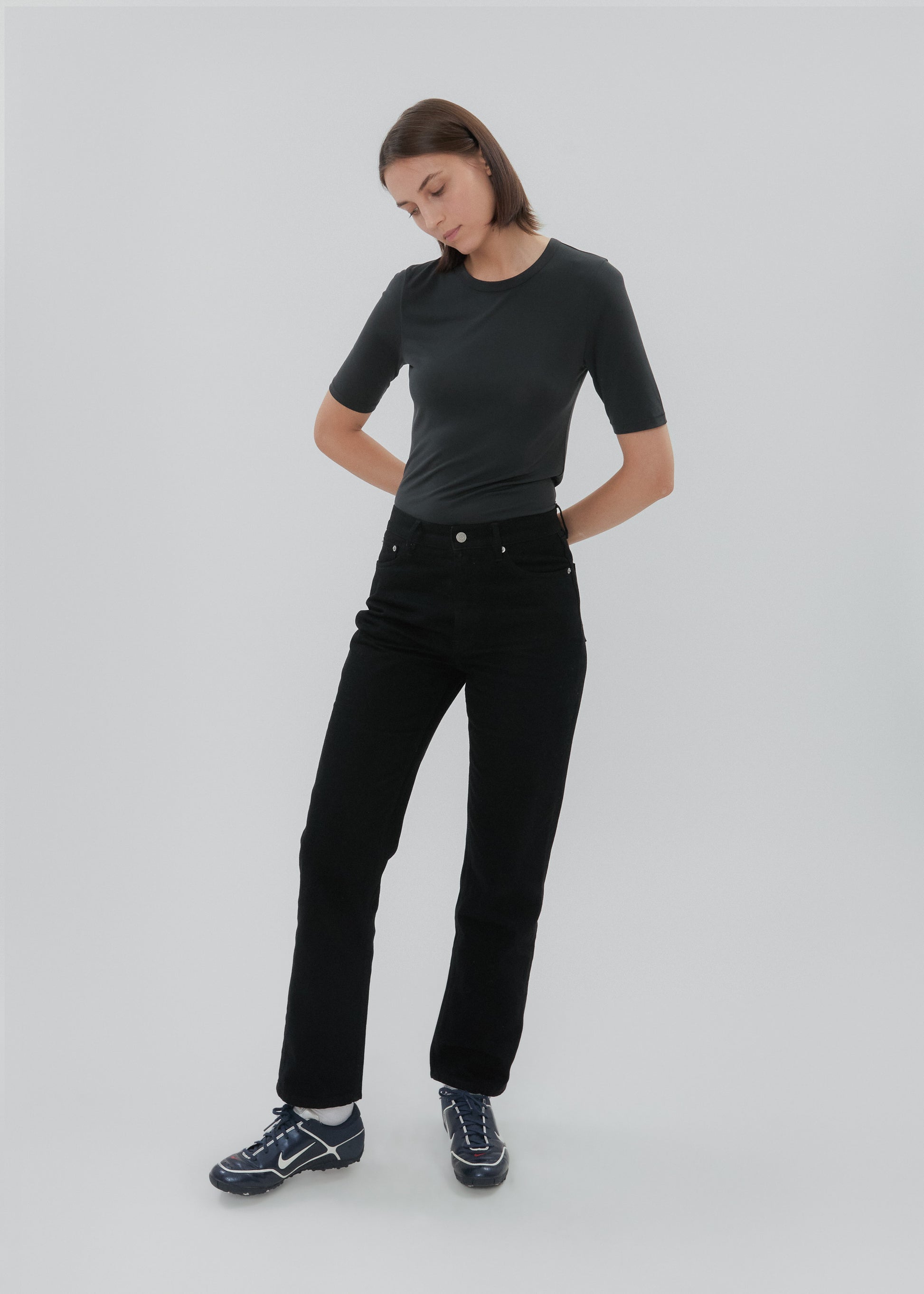 Person wearing a black t-shirt and black pants on a white background