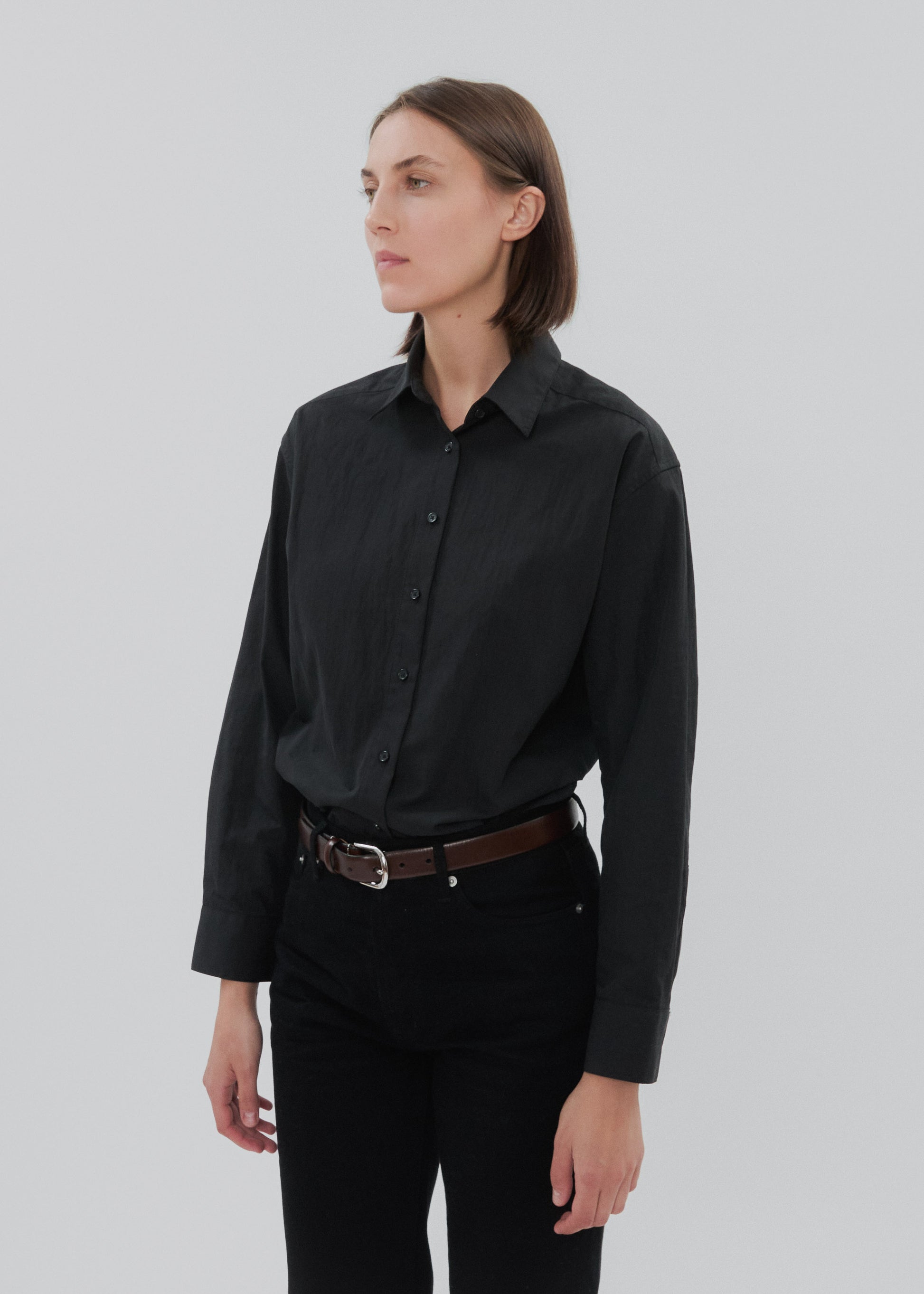 Person wearing a black shirt and pants on a plain background