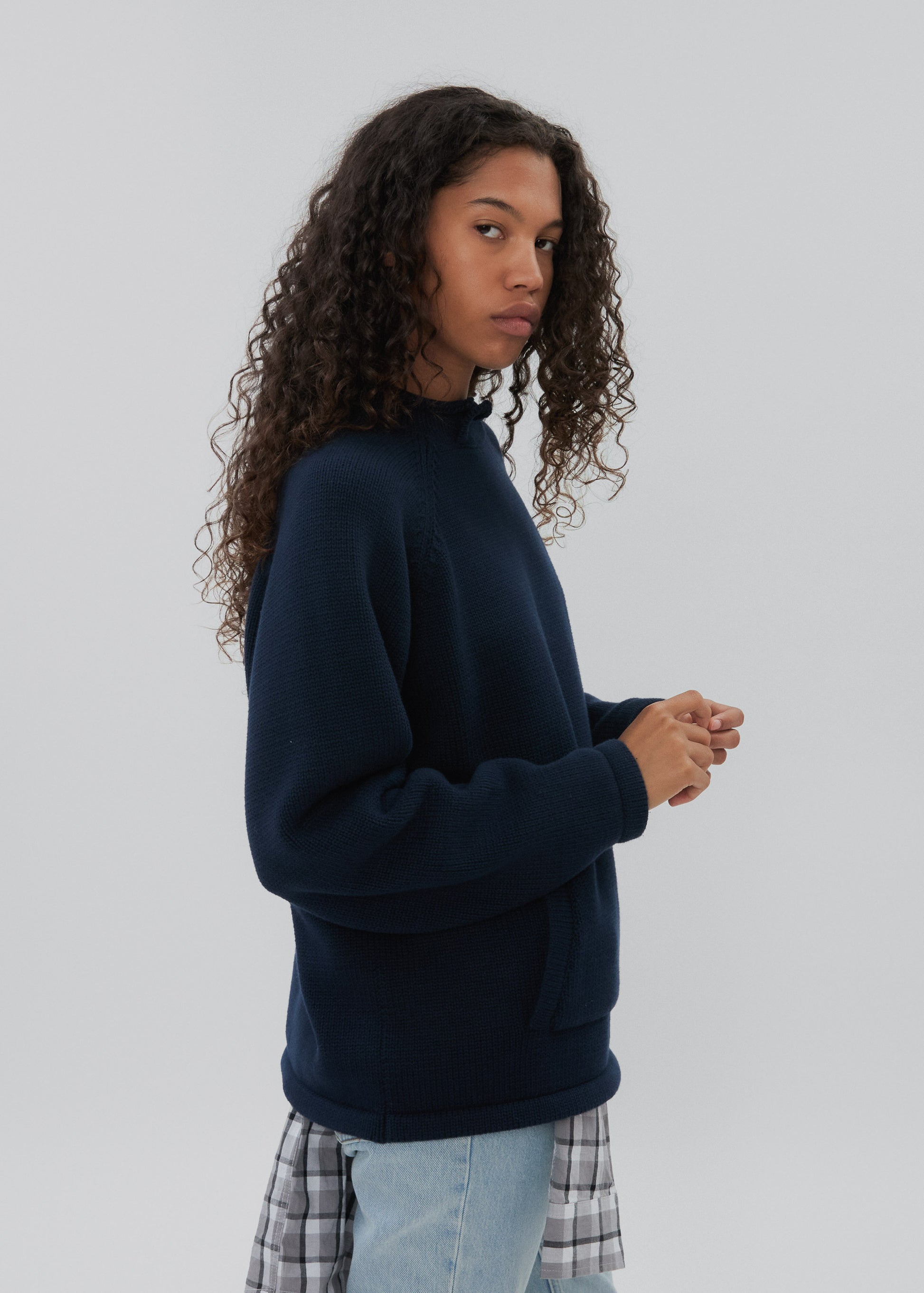 Person wearing a navy blue sweatshirt with a plain background