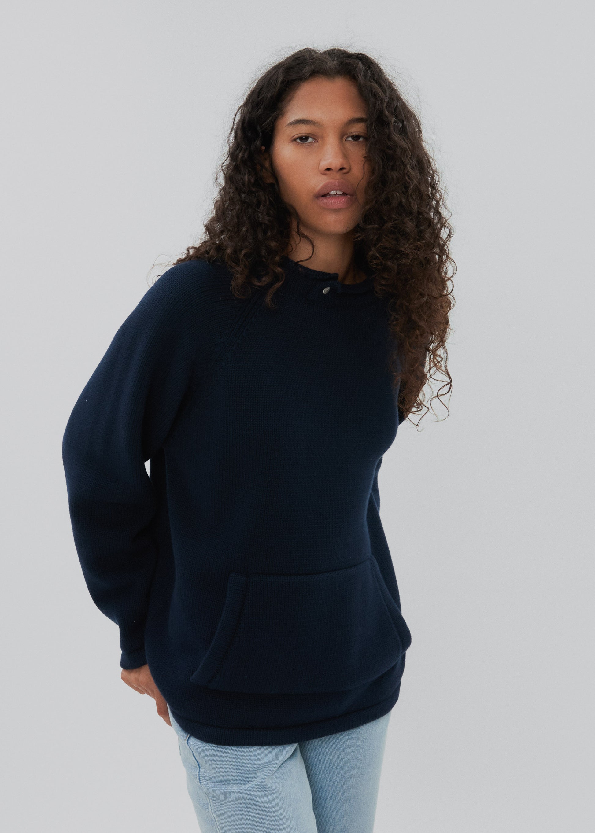 Person wearing a navy blue sweatshirt against a plain background
