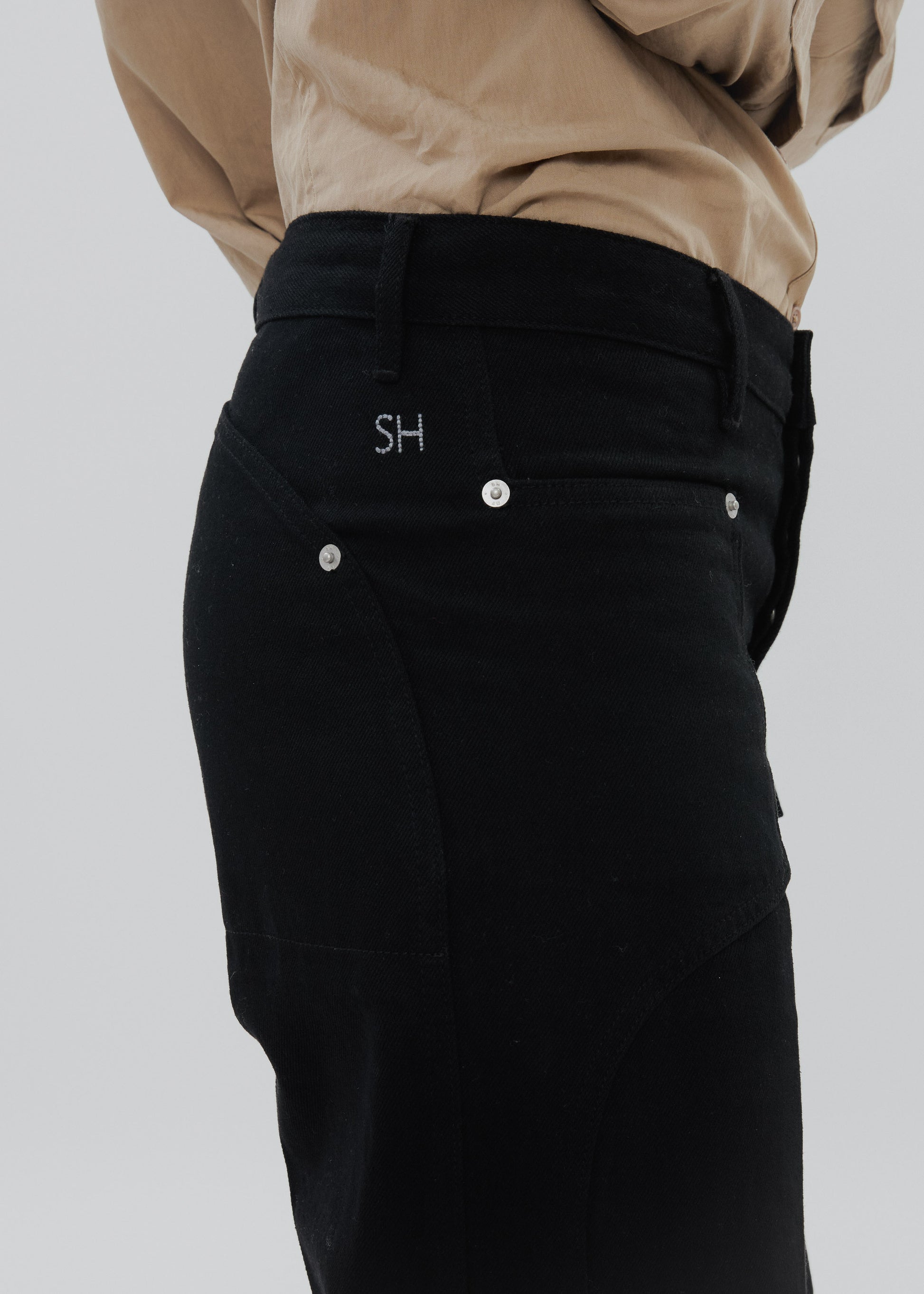 Black pants with a brand logo on a plain background