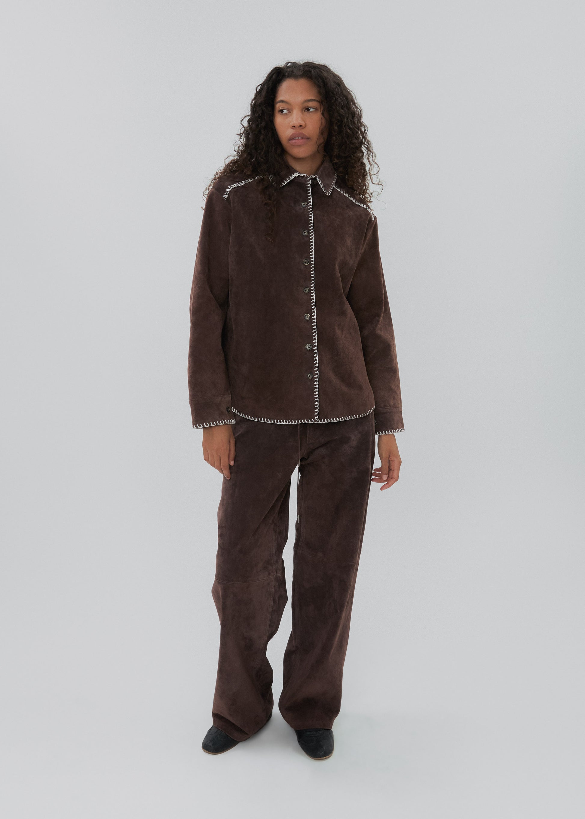 Person wearing a brown corduroy outfit on a white background