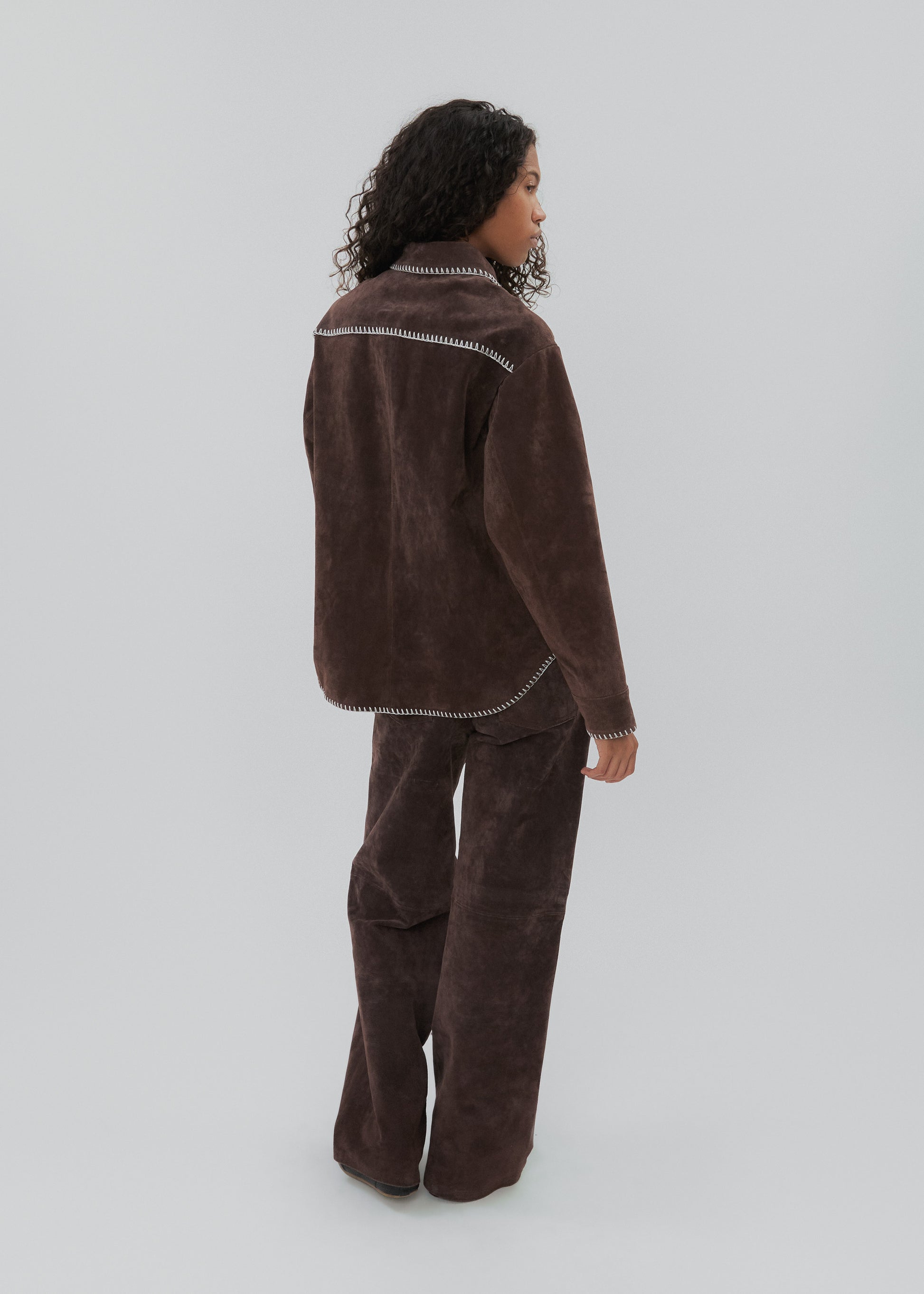 Person wearing a brown fleece outfit on a white background