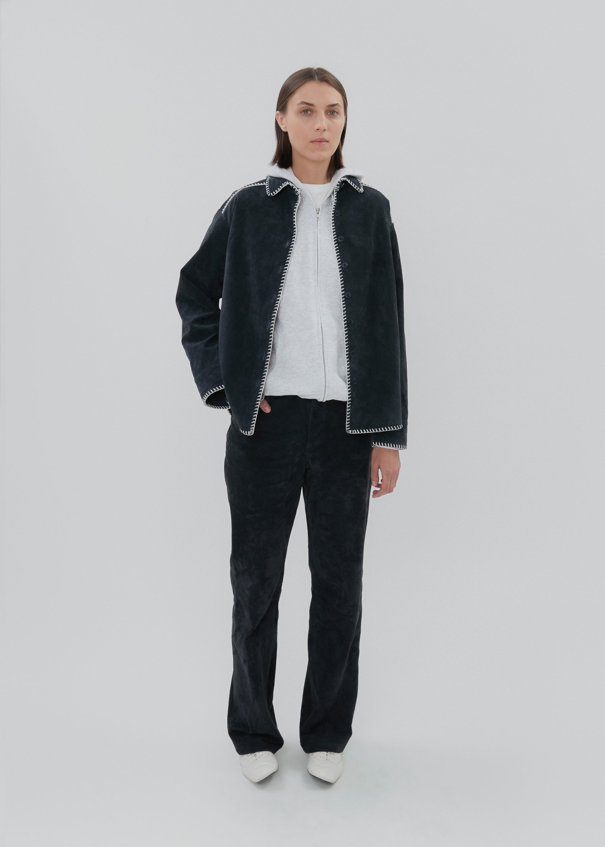 Person wearing a black jacket with white trim on a white background