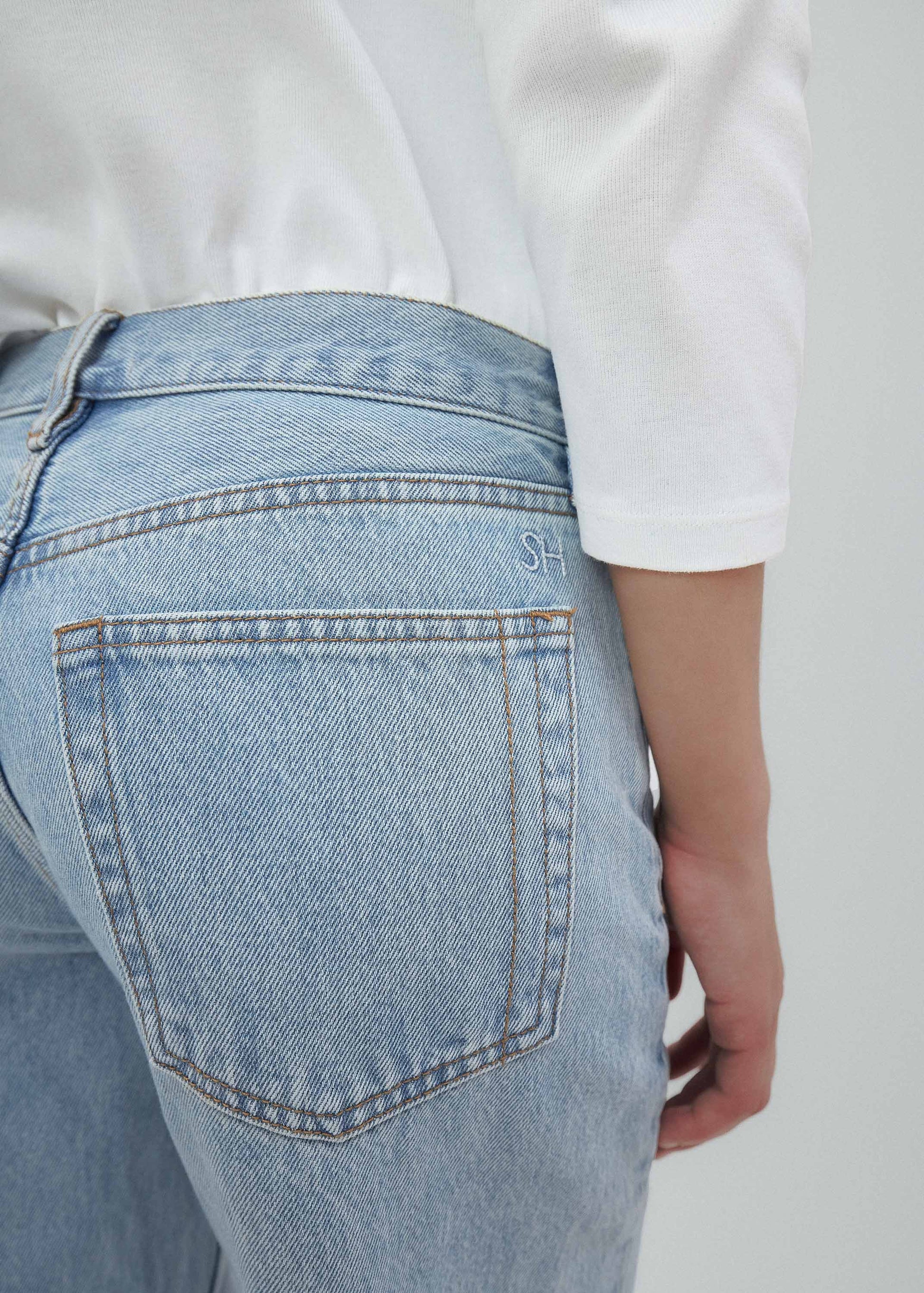 Light blue jeans worn by a person on a plain background