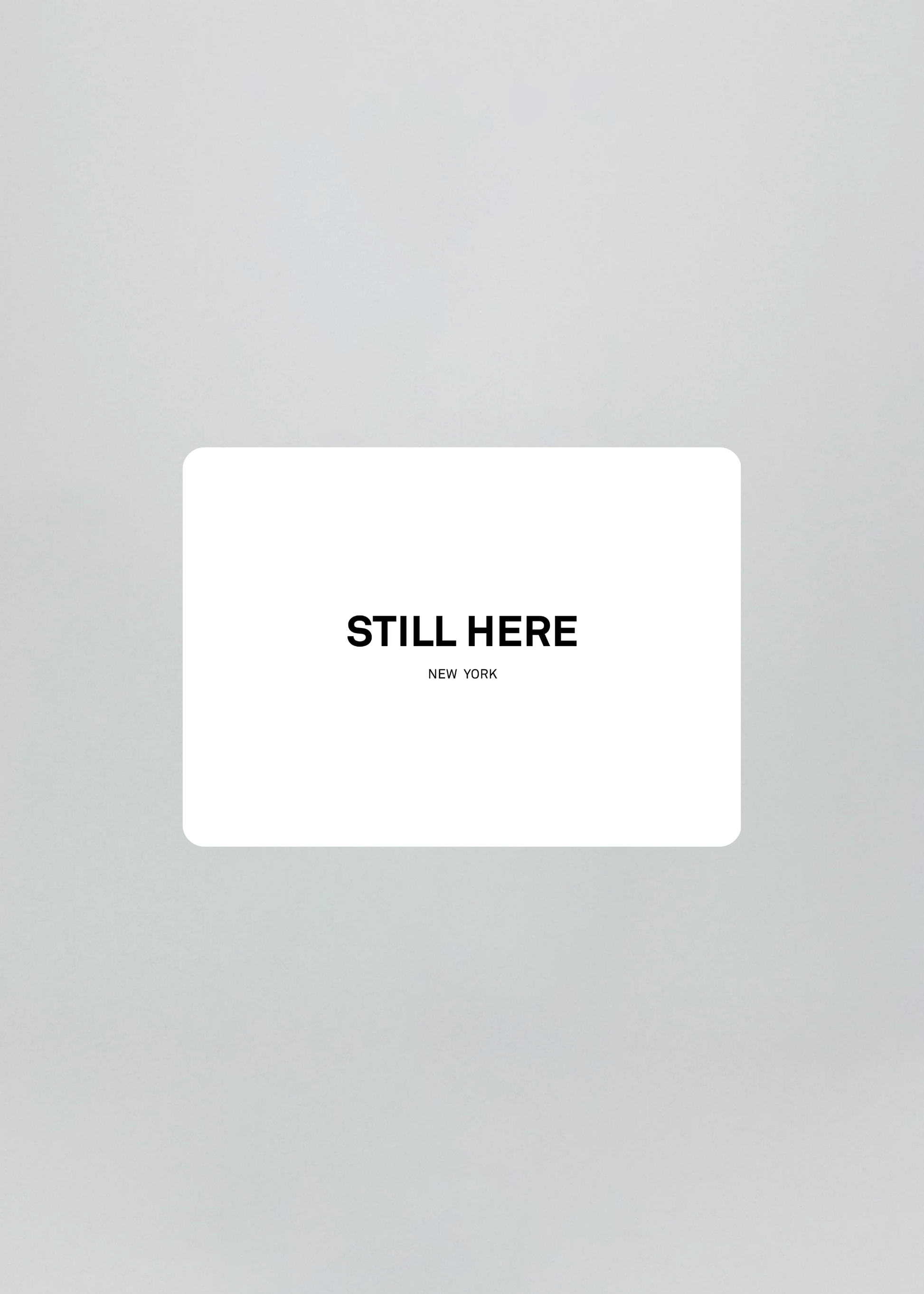 White card with 'STILL HERE NEW YORK' text on a gray background