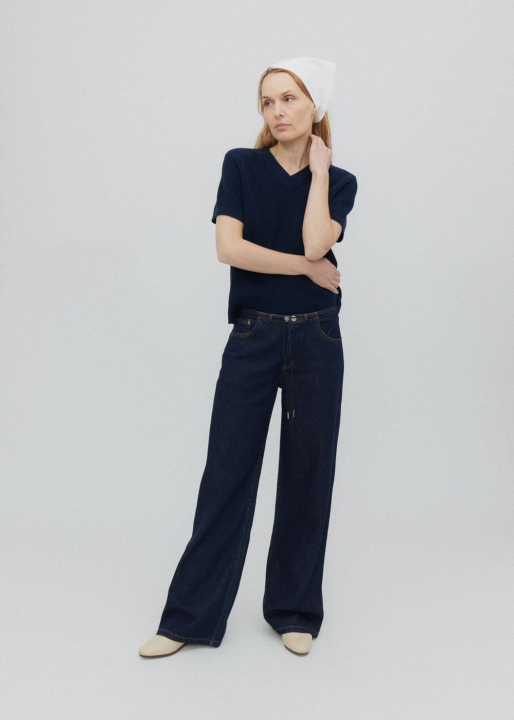 Woman wearing a navy blue outfit with a white background