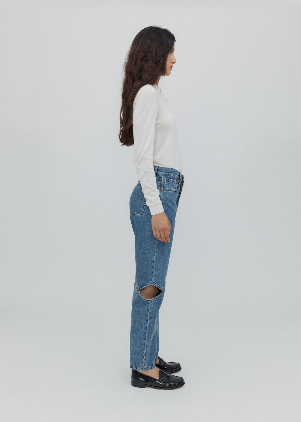 Person wearing blue jeans with a white background