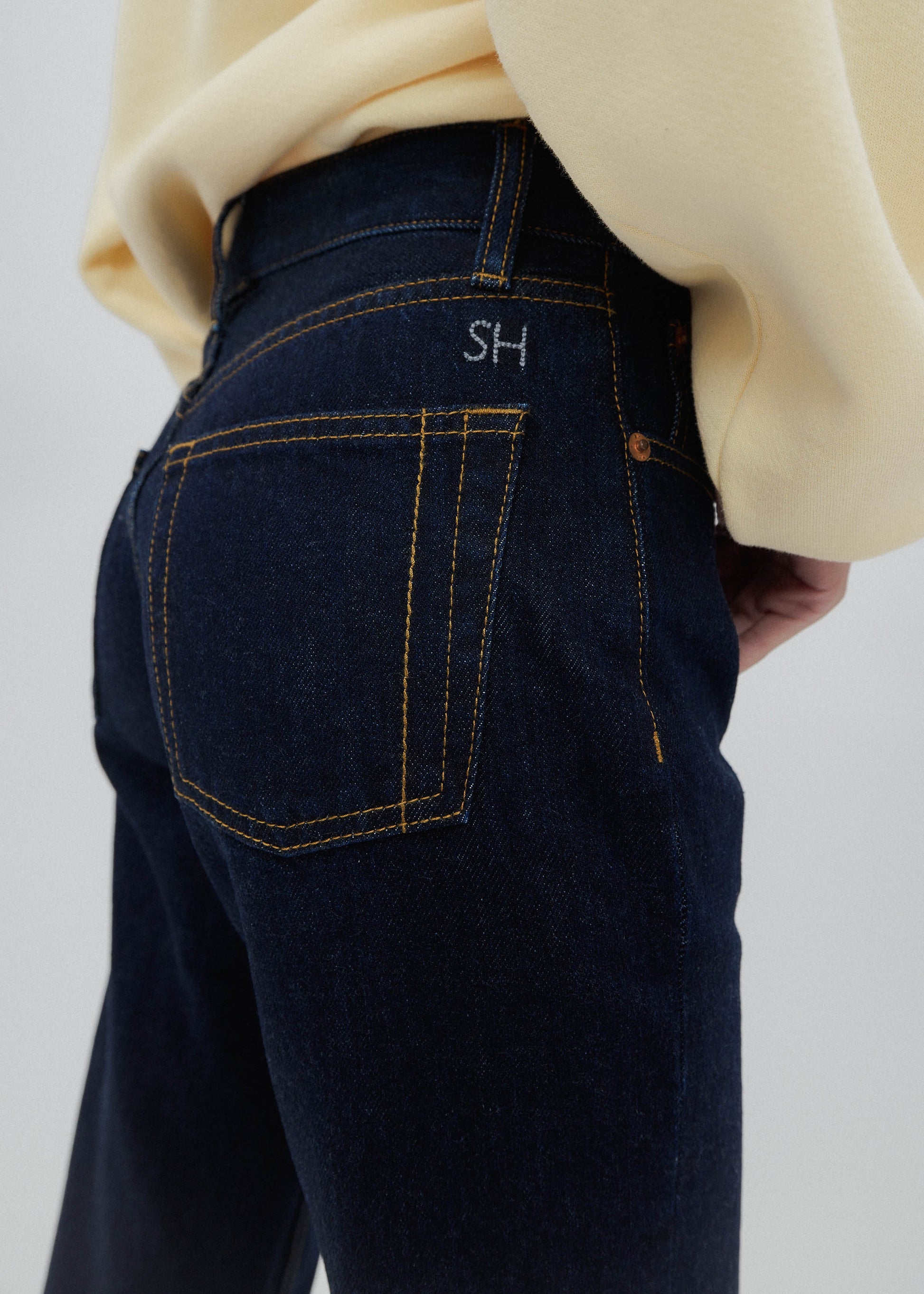 Dark blue jeans with a visible brand logo on a plain background