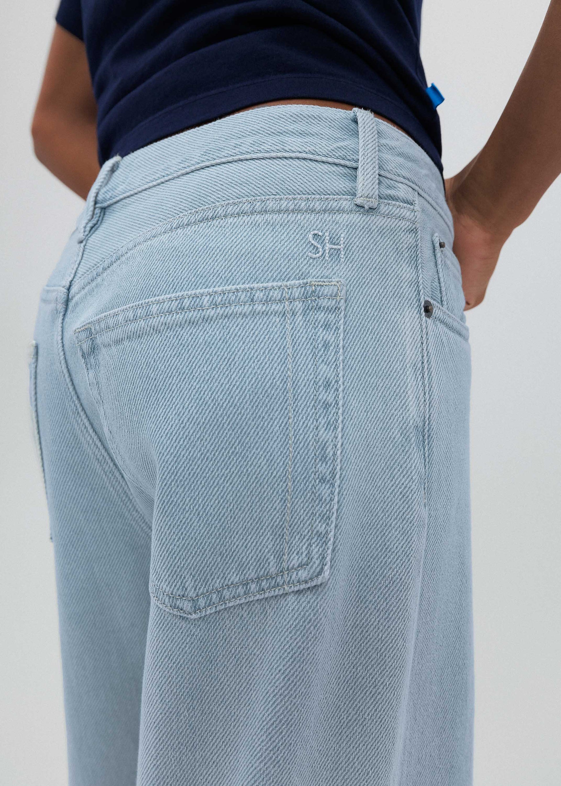 Light blue jeans with a visible brand logo on a plain background