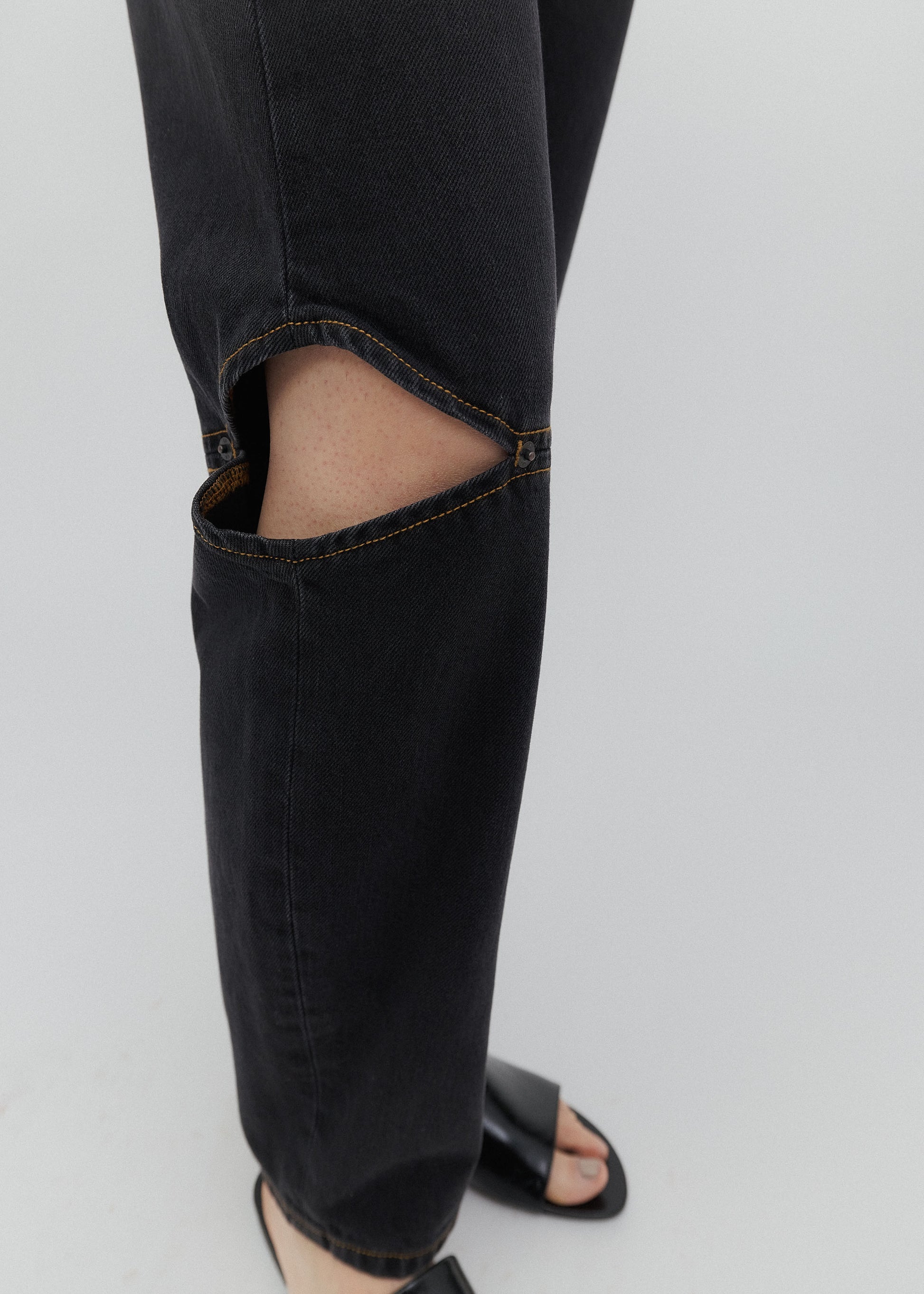 Black jeans with a tear on a white background