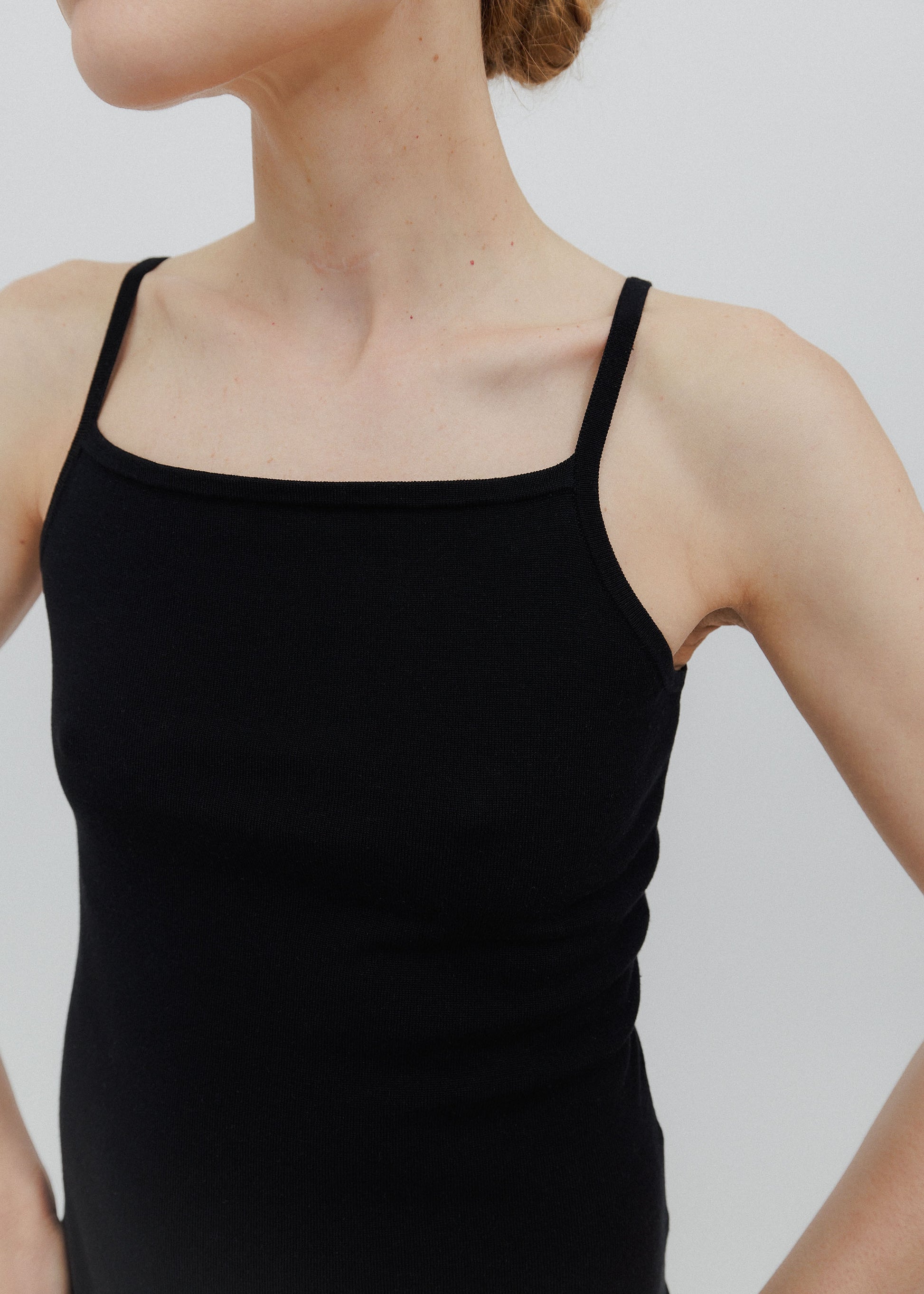 Black tank top worn by a person on a plain background