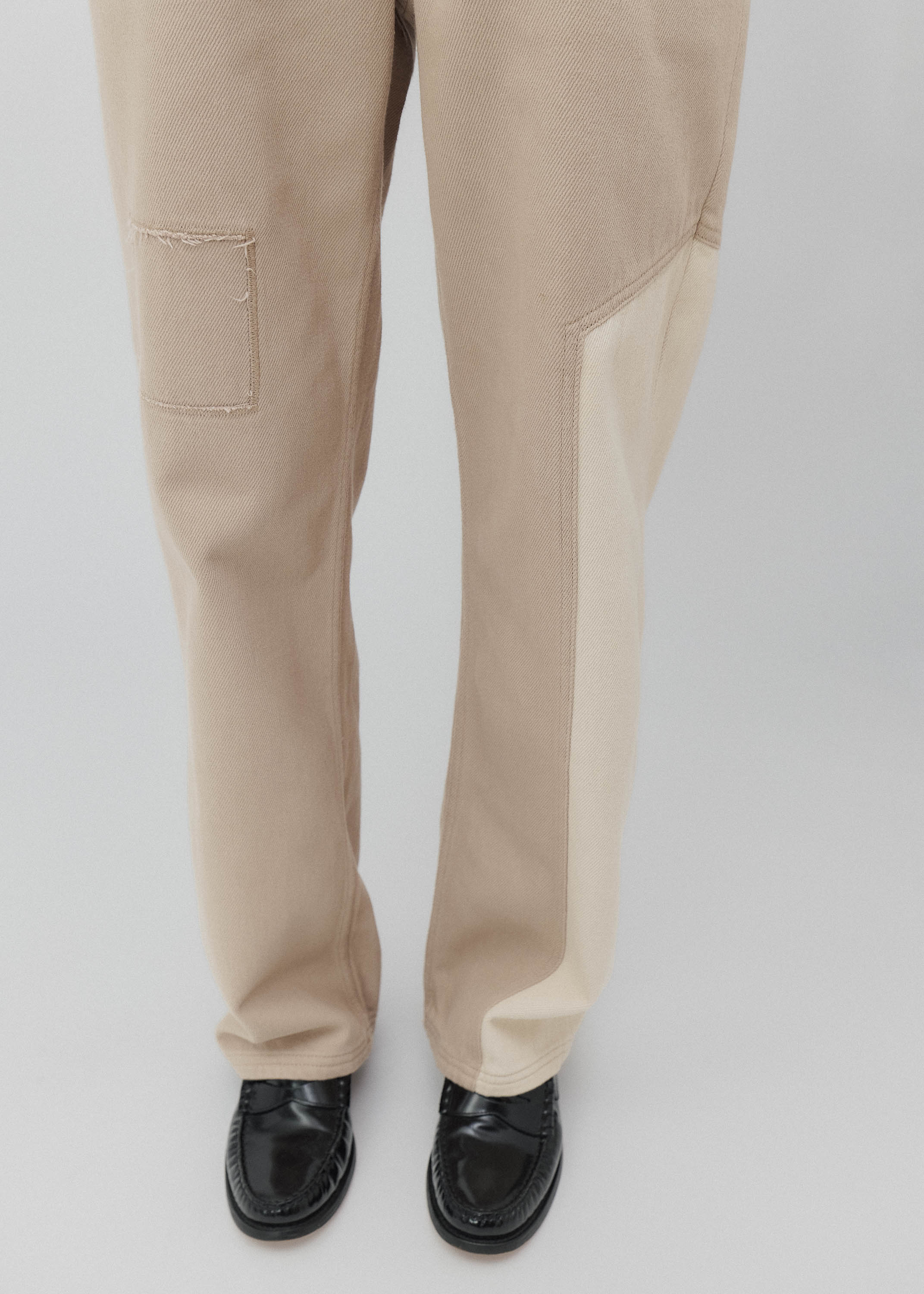 Beige pants worn by a person on a light gray background