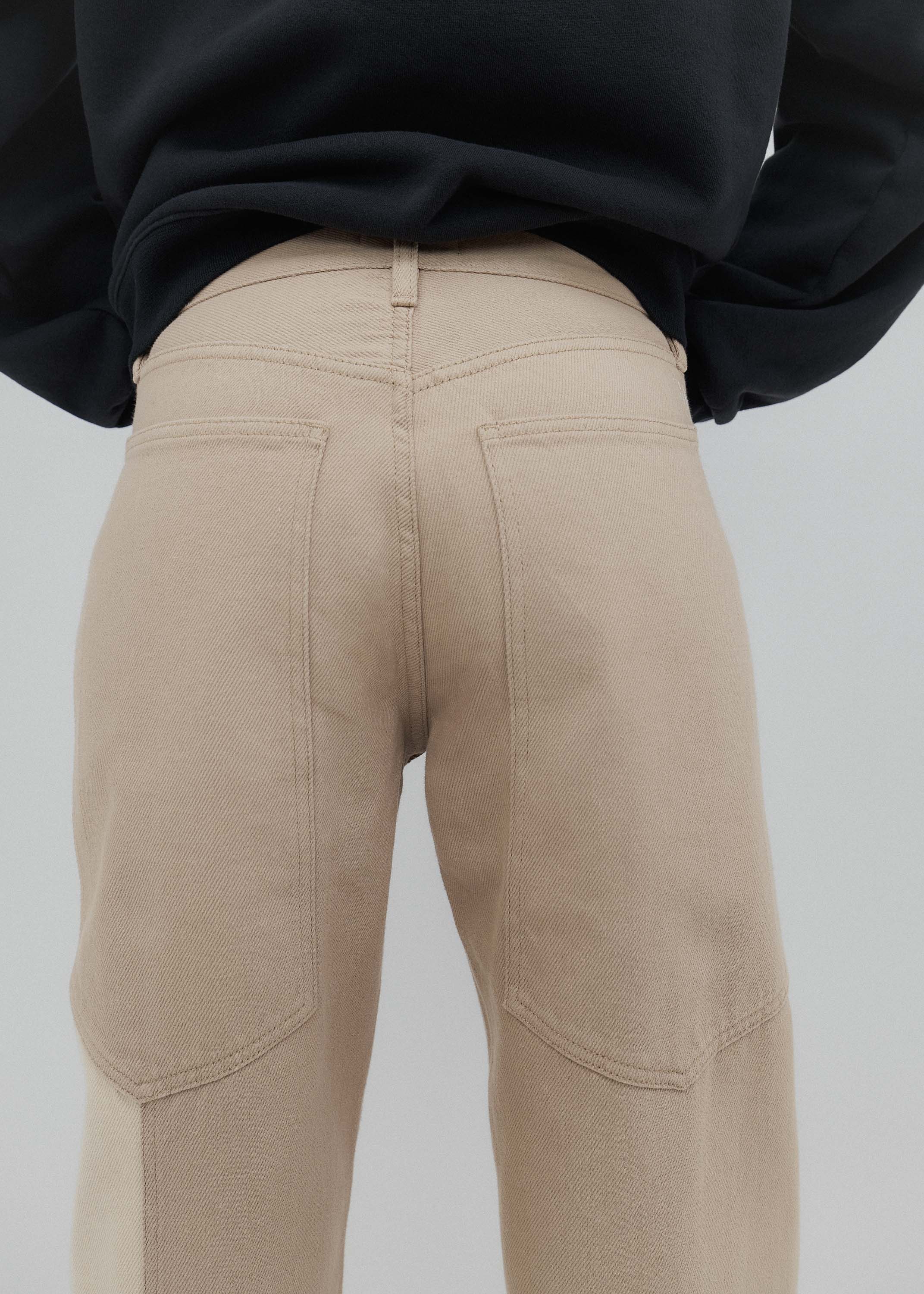 Beige pants worn by a person with a plain background