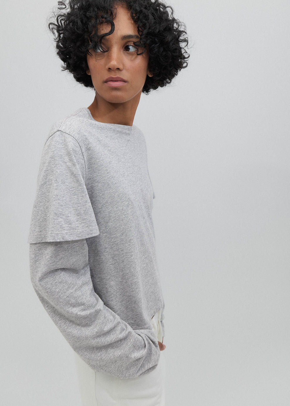 Person wearing a gray sweatshirt against a plain background