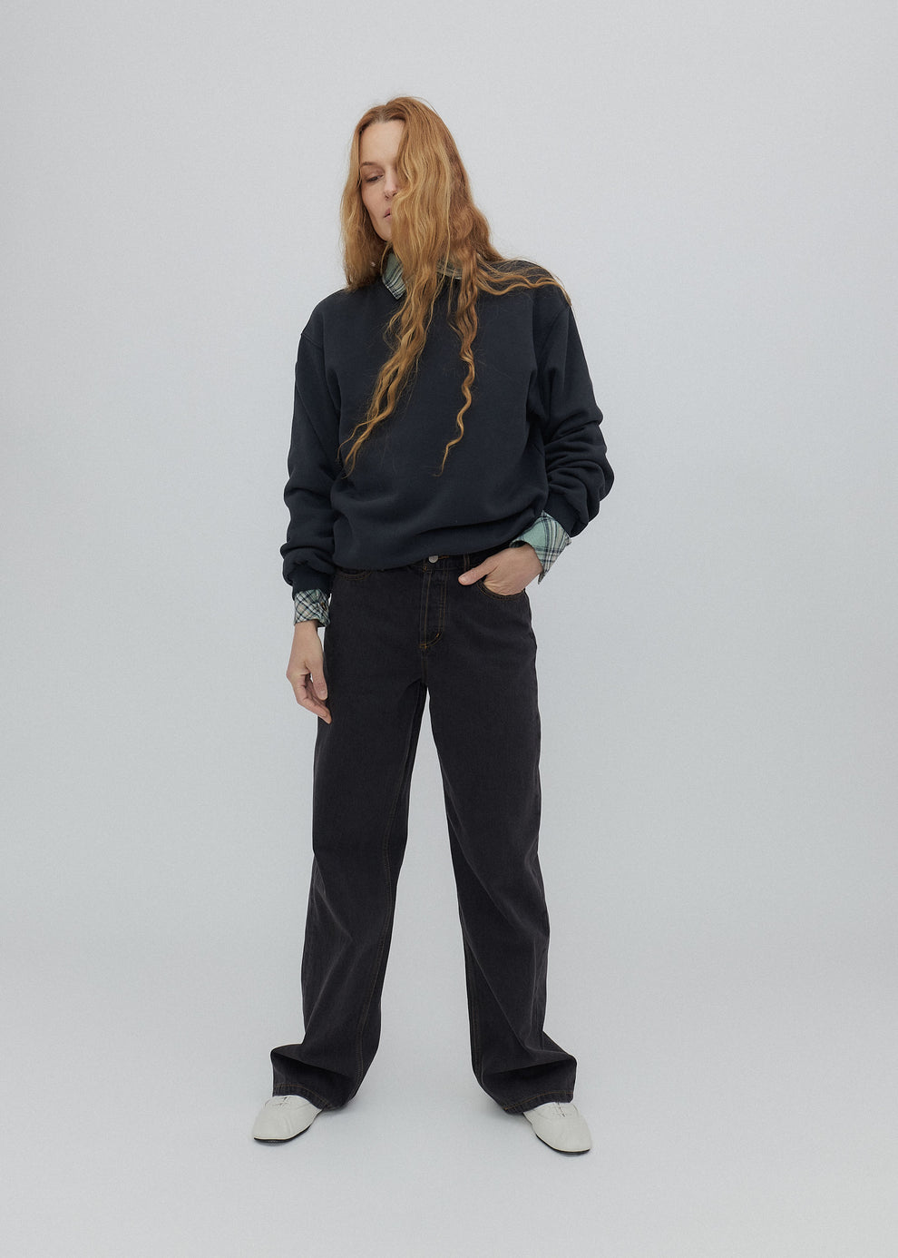 Person wearing a black sweatshirt and pants on a white background