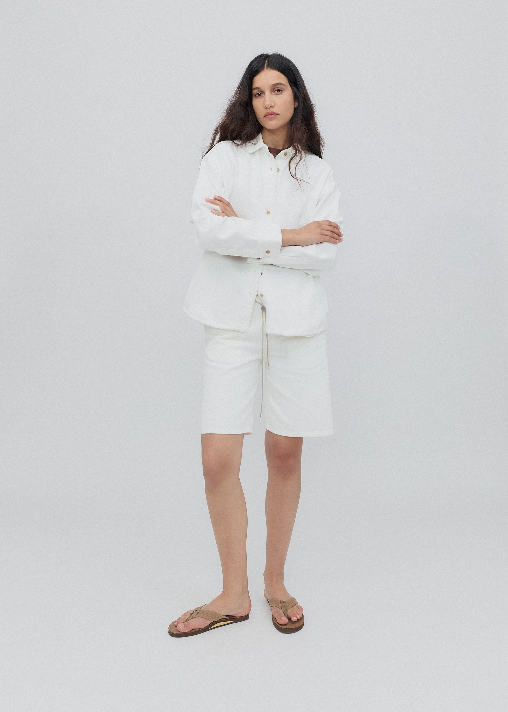 Woman wearing a white outfit on a plain background
