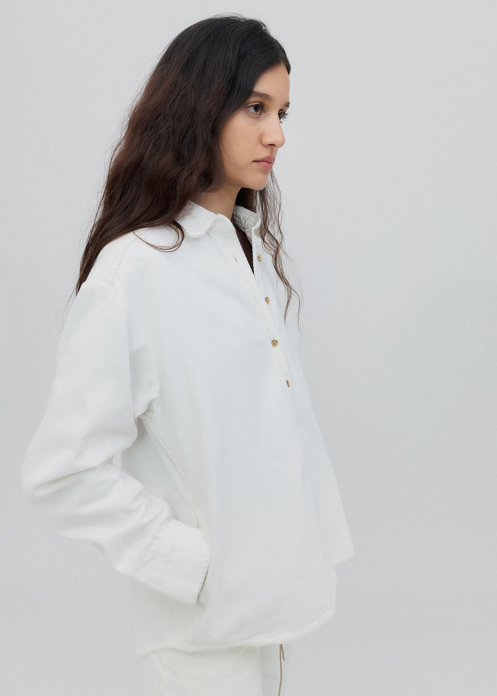 Woman wearing a white shirt against a plain background