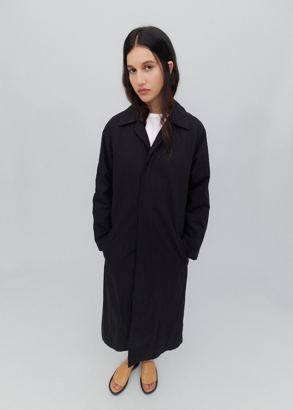 Woman wearing a black coat on a plain background