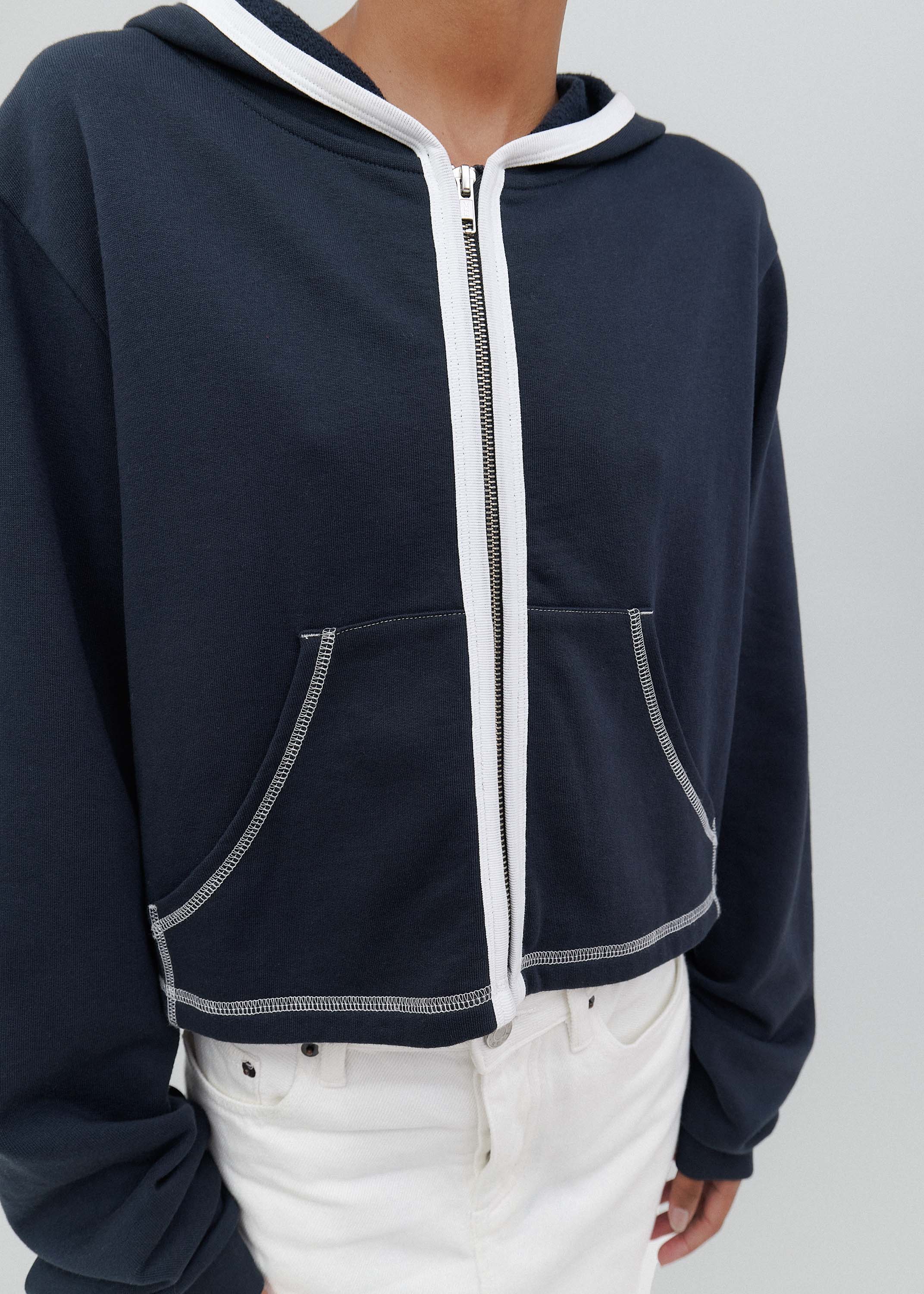 Navy blue hoodie with white trim on a plain background