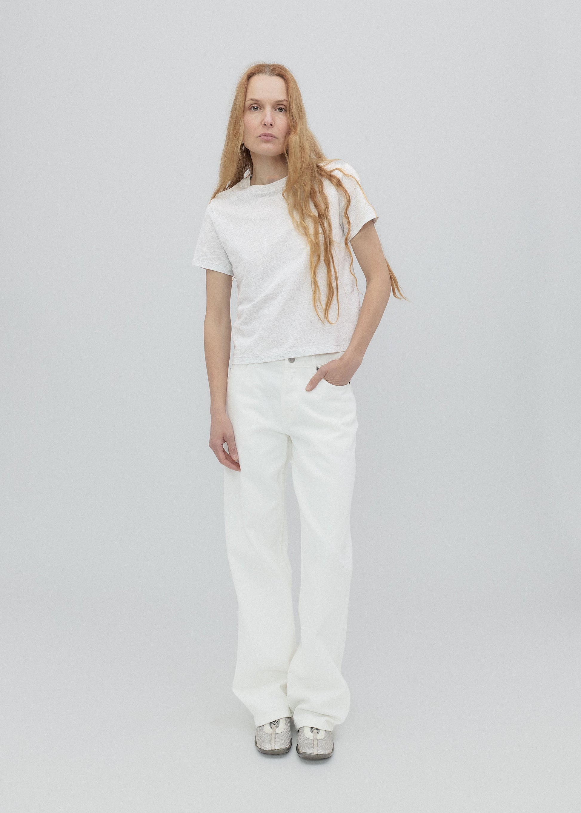 Person wearing a white t-shirt and pants on a plain background