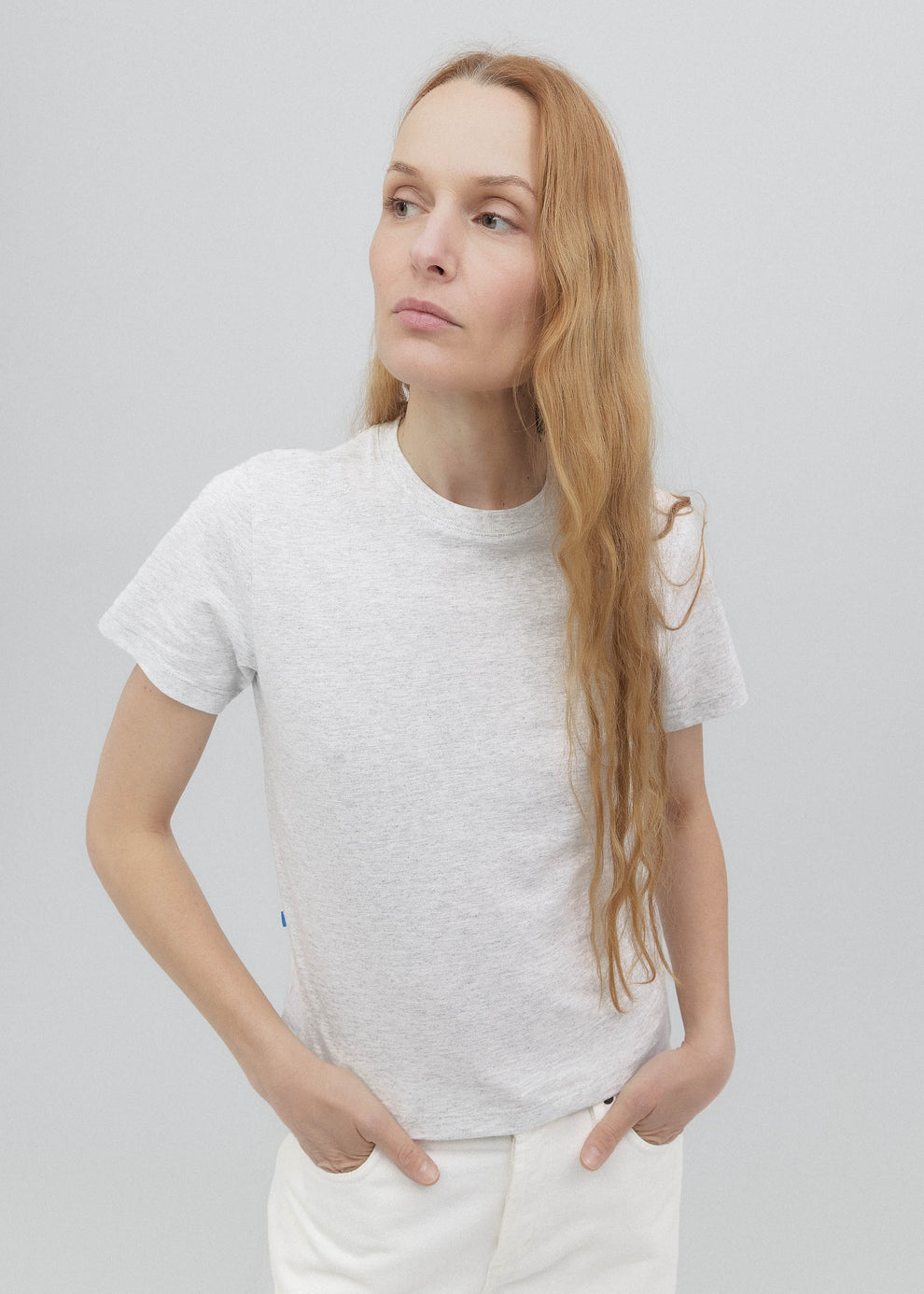 Woman wearing a white t-shirt against a plain background