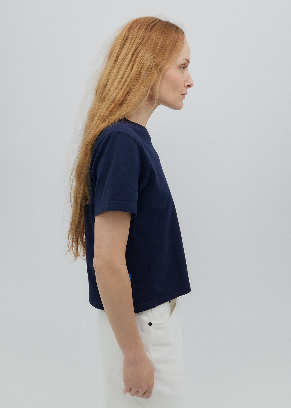 Woman wearing a navy blue t-shirt against a white background