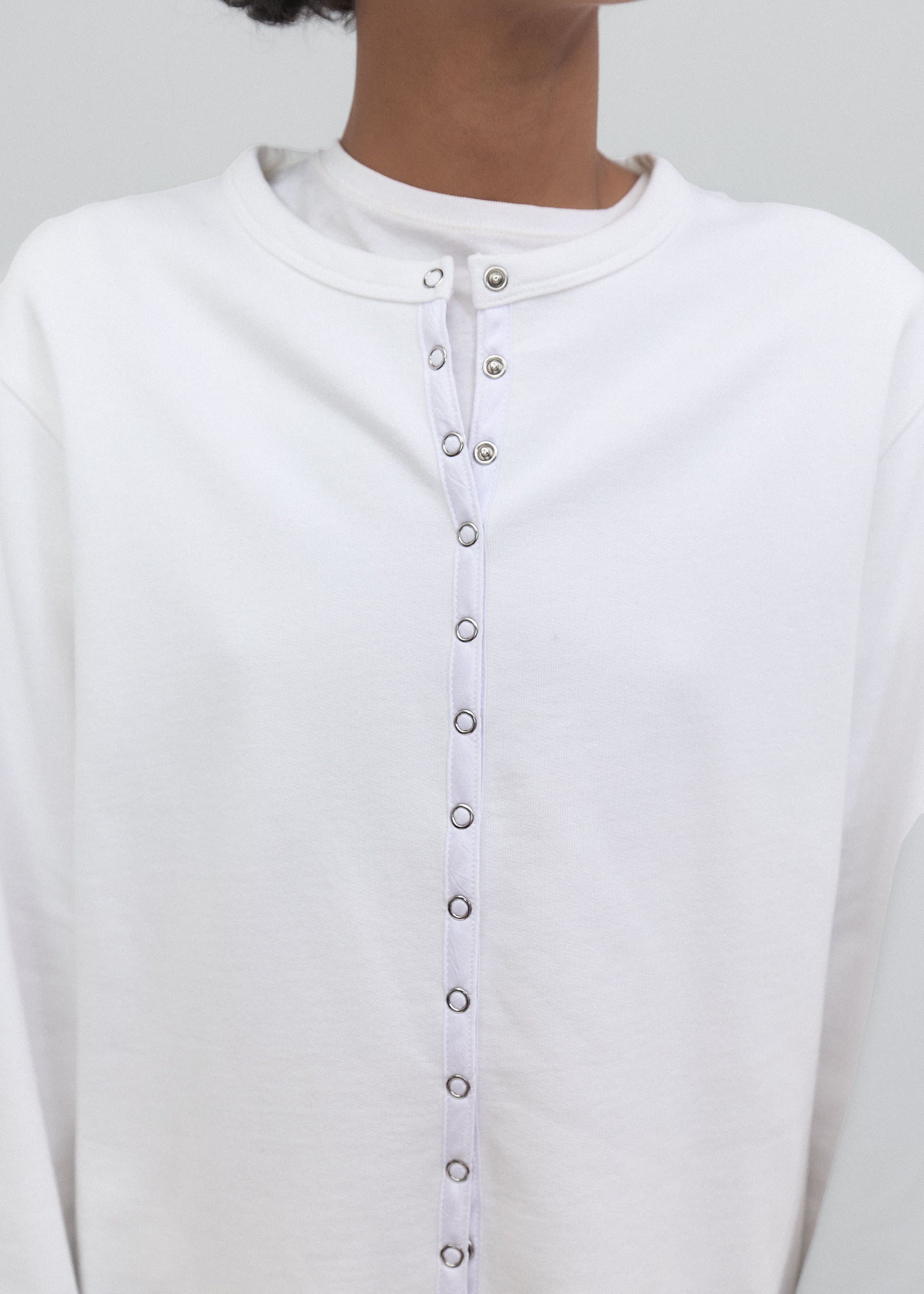 Close-up of a white shirt with buttons on a plain background