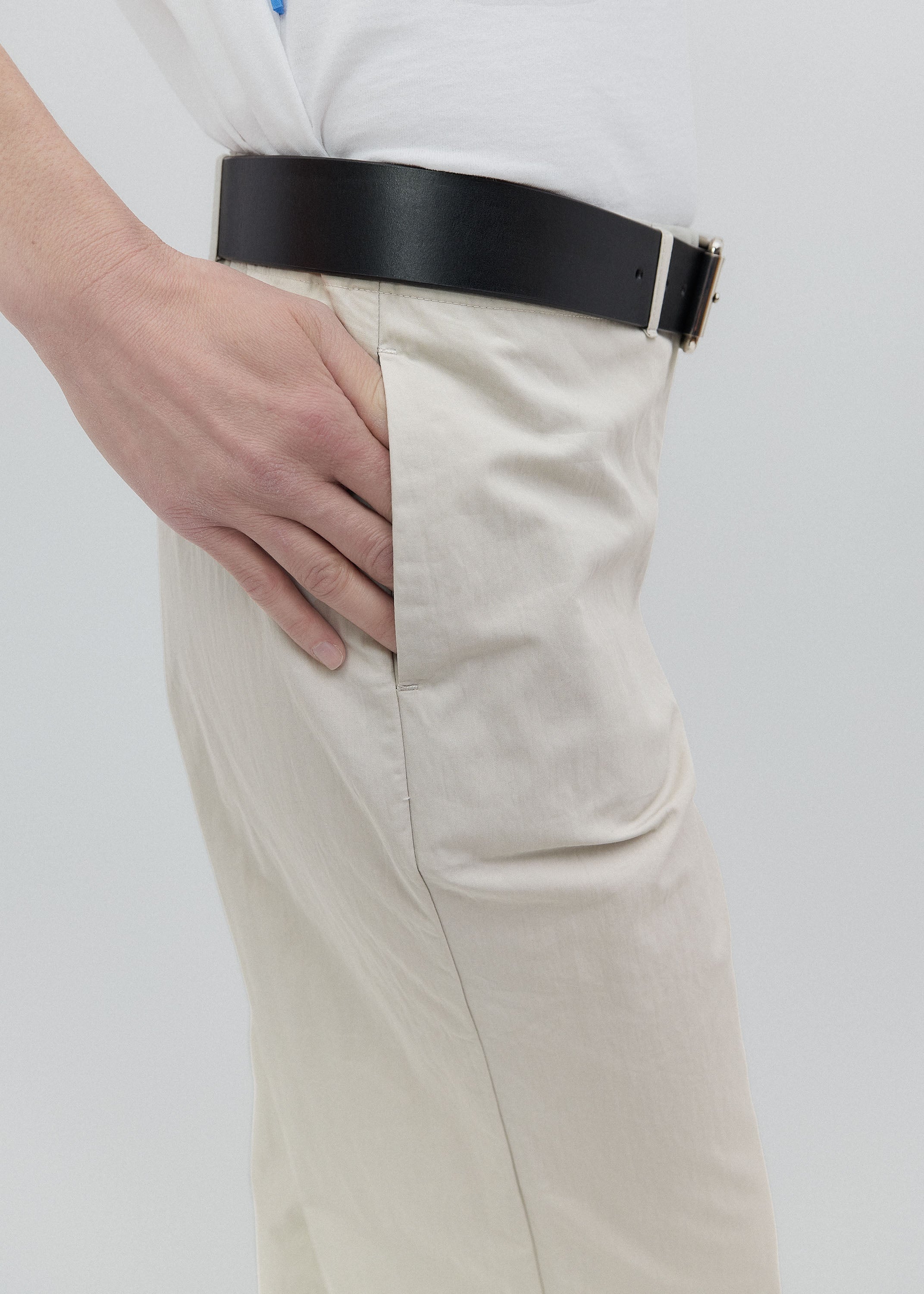 Beige pants with a black belt on a white background