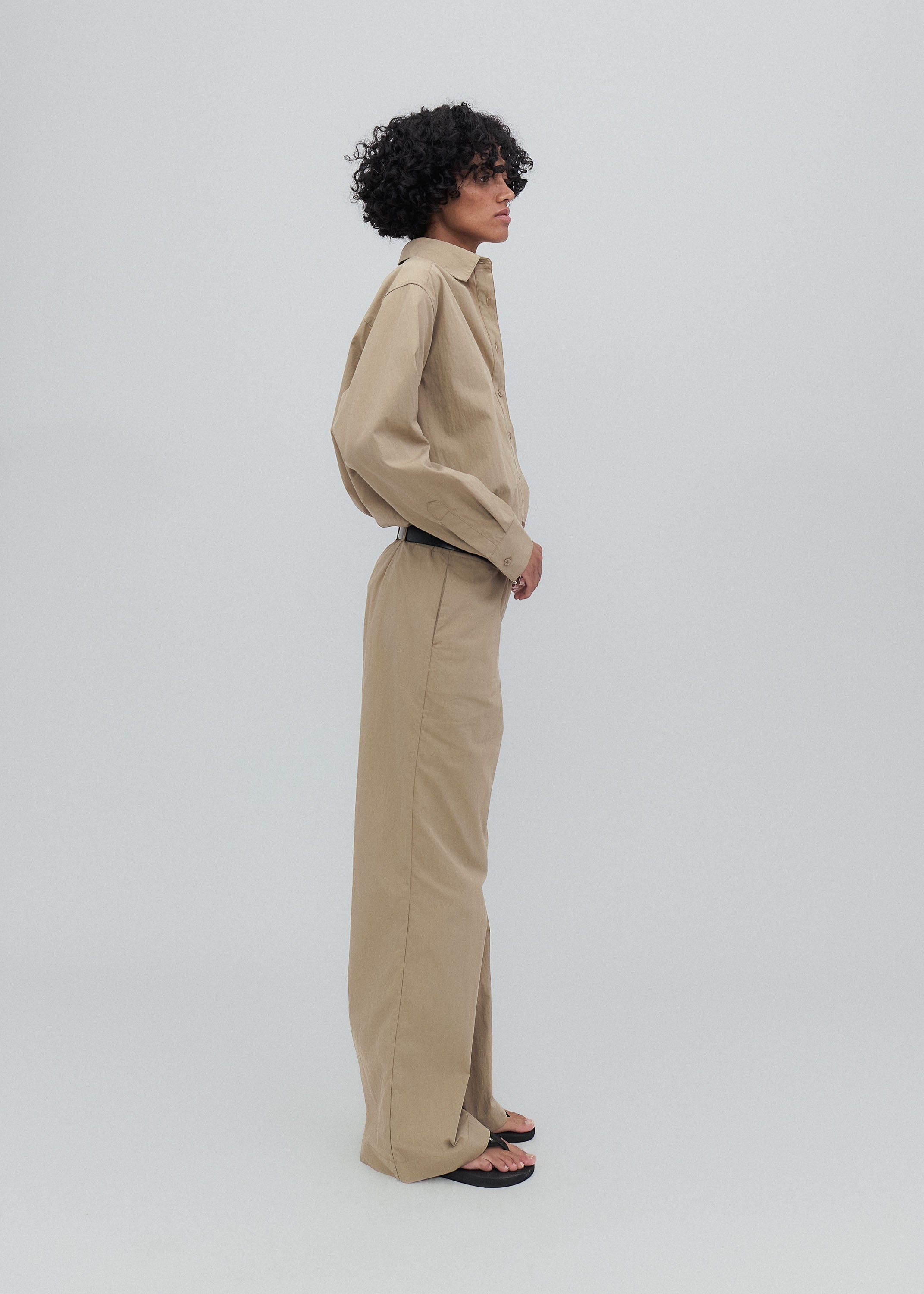 Person wearing a beige outfit on a white background
