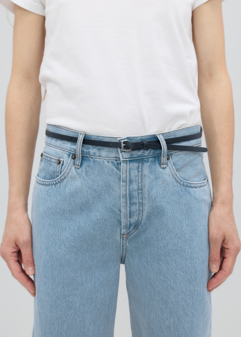 Light blue jeans worn by a person on a plain background