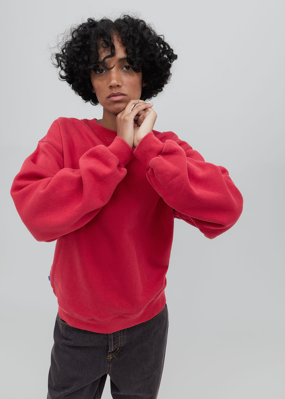 Person wearing a red sweatshirt against a plain background