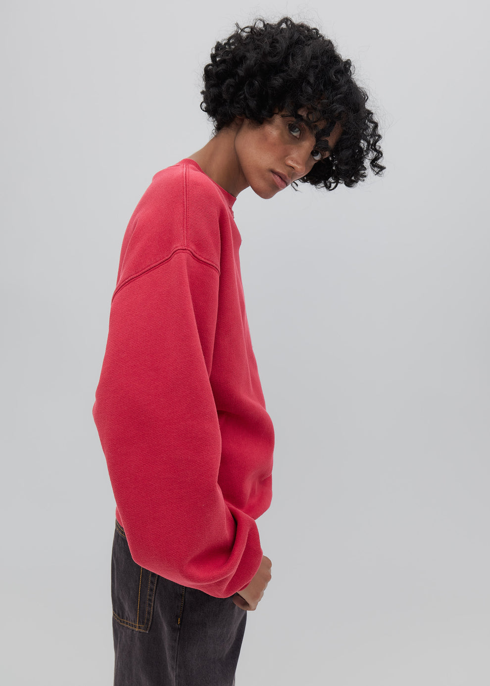 Person wearing a red sweatshirt on a plain background