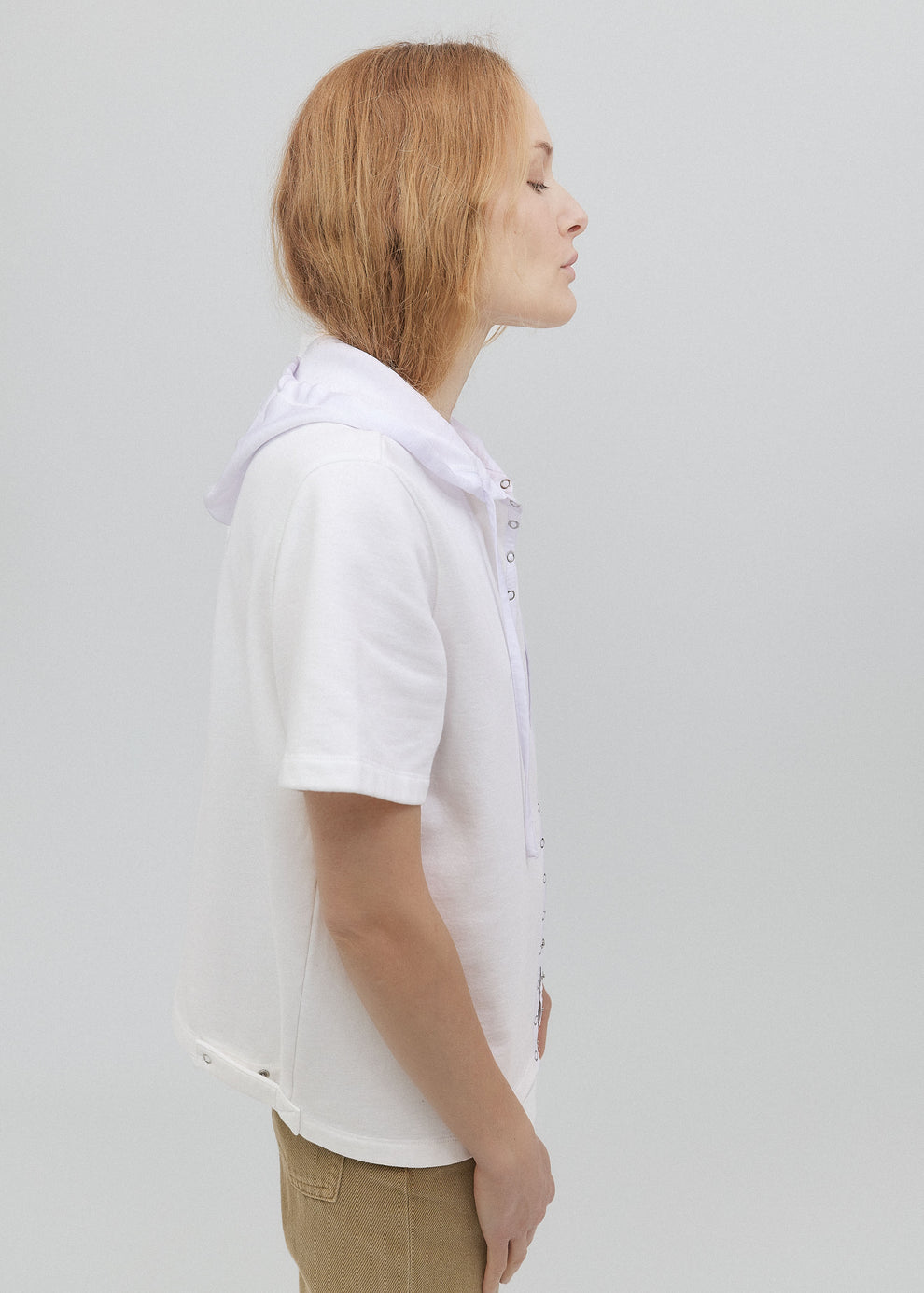 Person wearing a white shirt with a collar against a plain background