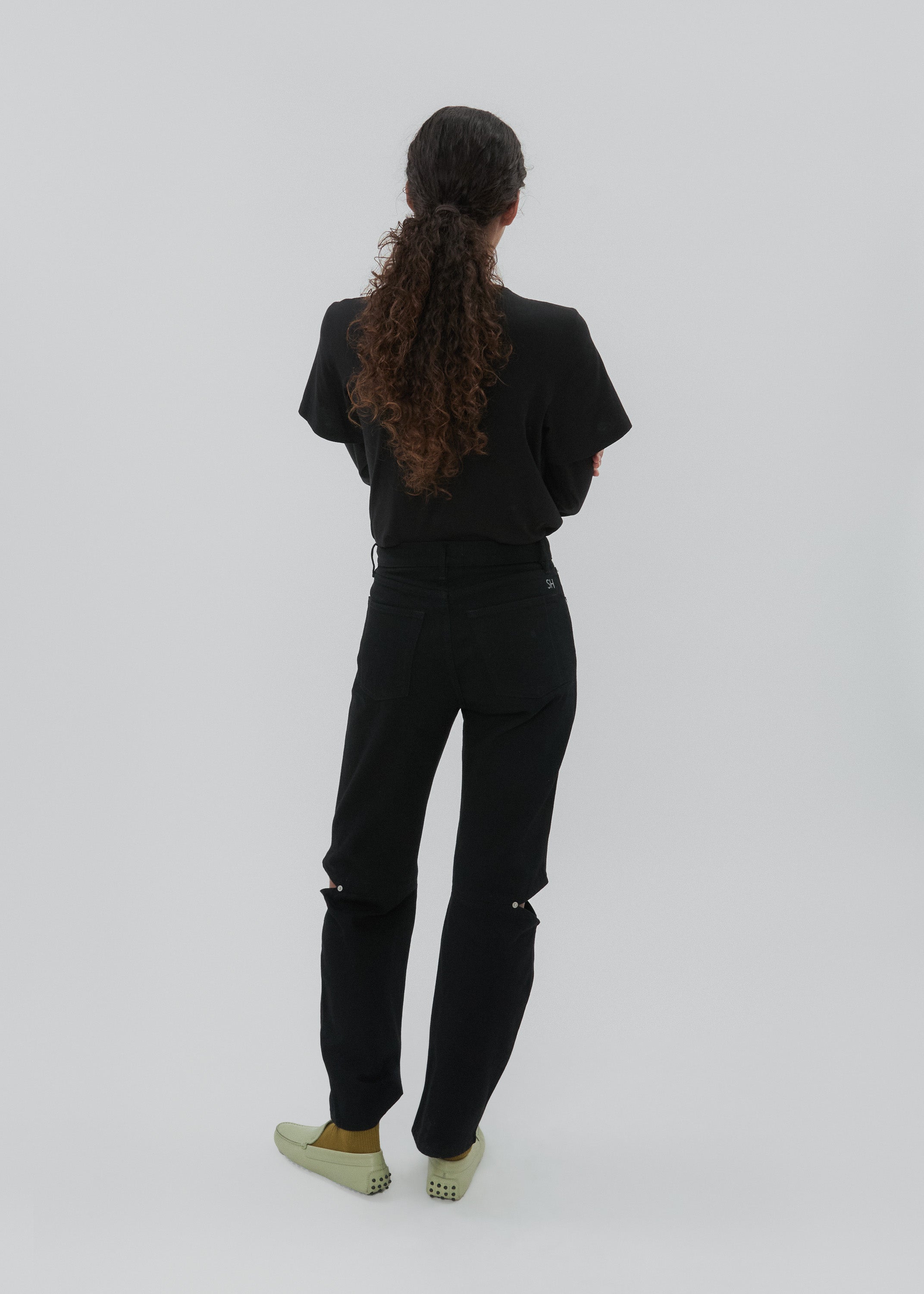 Person wearing a black outfit on a white background
