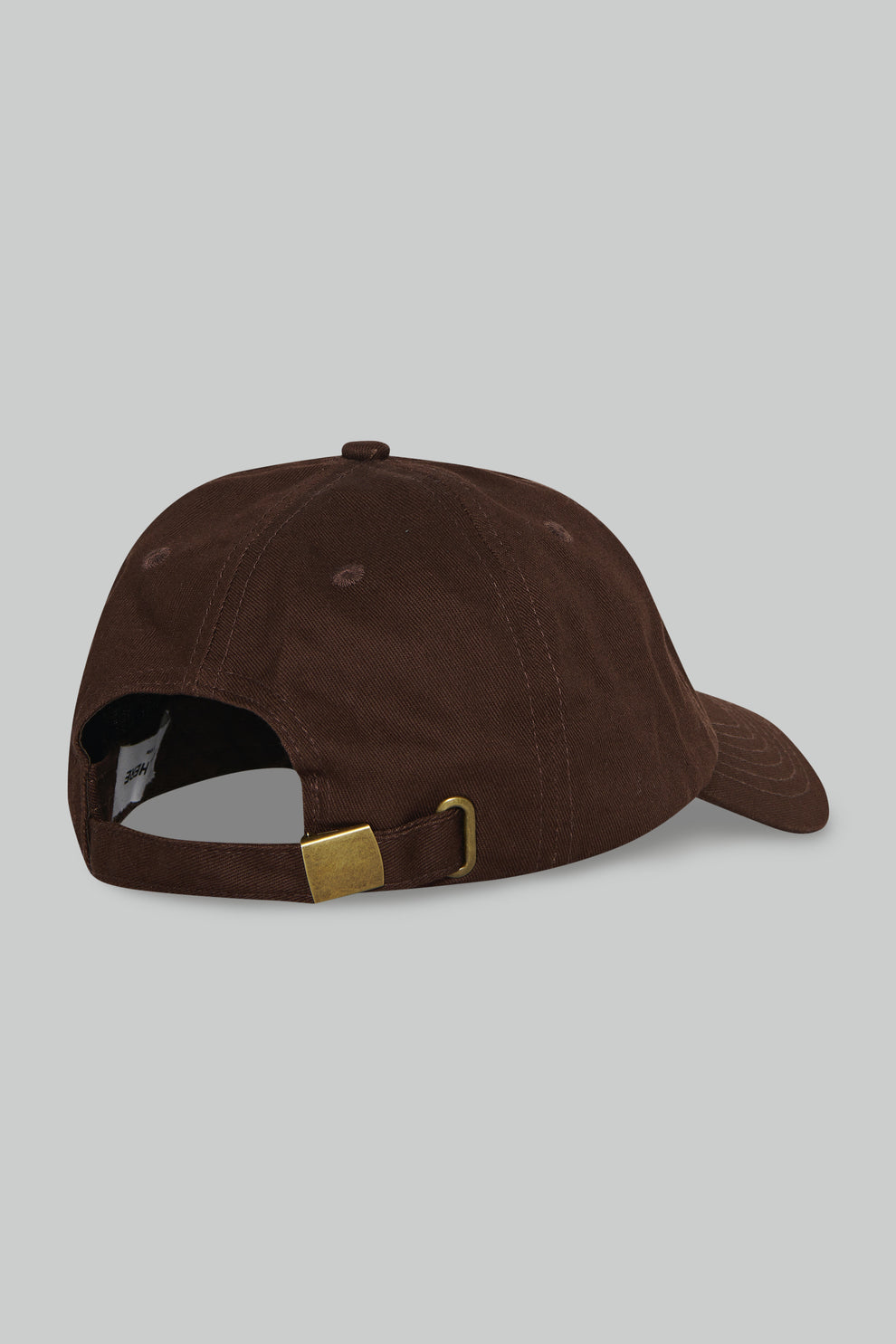 Brown cap with a gold buckle on a gray background
